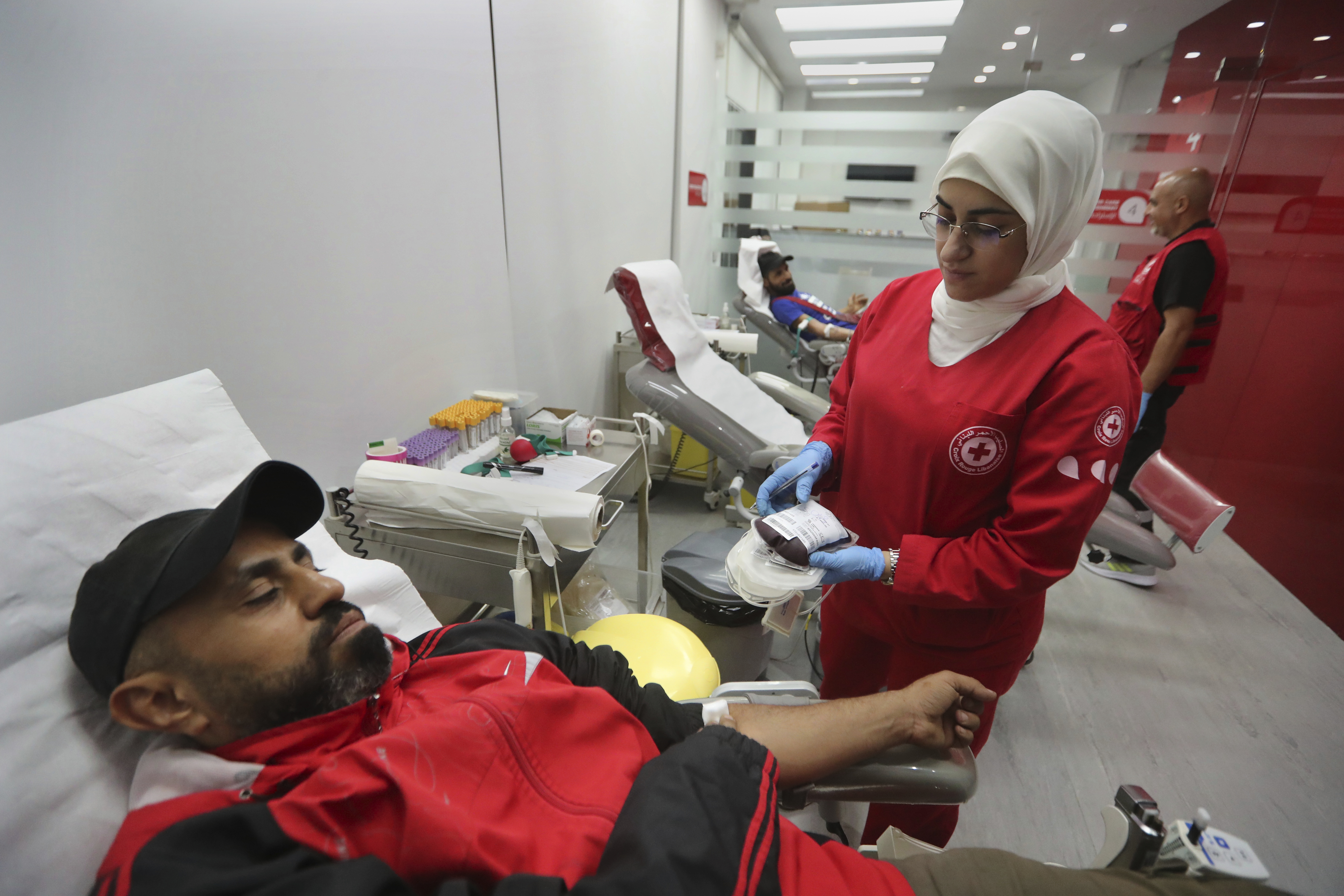 People donate blood for those who were injured by their exploded handheld pagers, at a Red Cross center, in the southern port city of Sidon, Lebanon, Tuesday, Sept. 17, 2024. (AP Photo/Mohammed Zaatari)