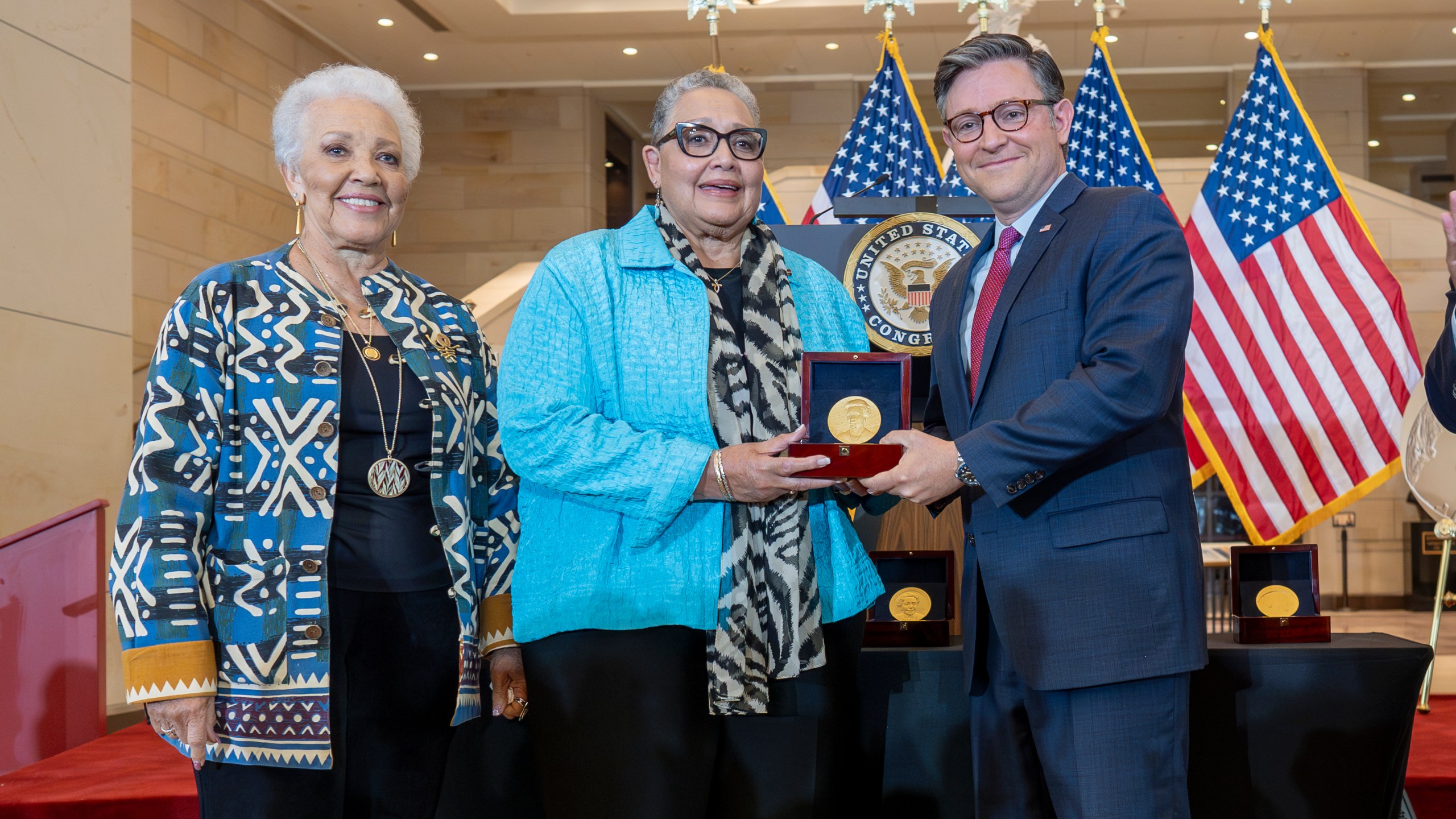 House Speaker Mike Johnson, R-La., center, presents a Congressional Gold Medal posthumously to Joylette Hylick, left, and Katherine Moore, daughters of Katherine Johnson, the Black NASA mathematician featured in the movie "Hidden Figures," at the Capitol in Washington, Wednesday, Sept. 18, 2024. (AP Photo/J. Scott Applewhite)