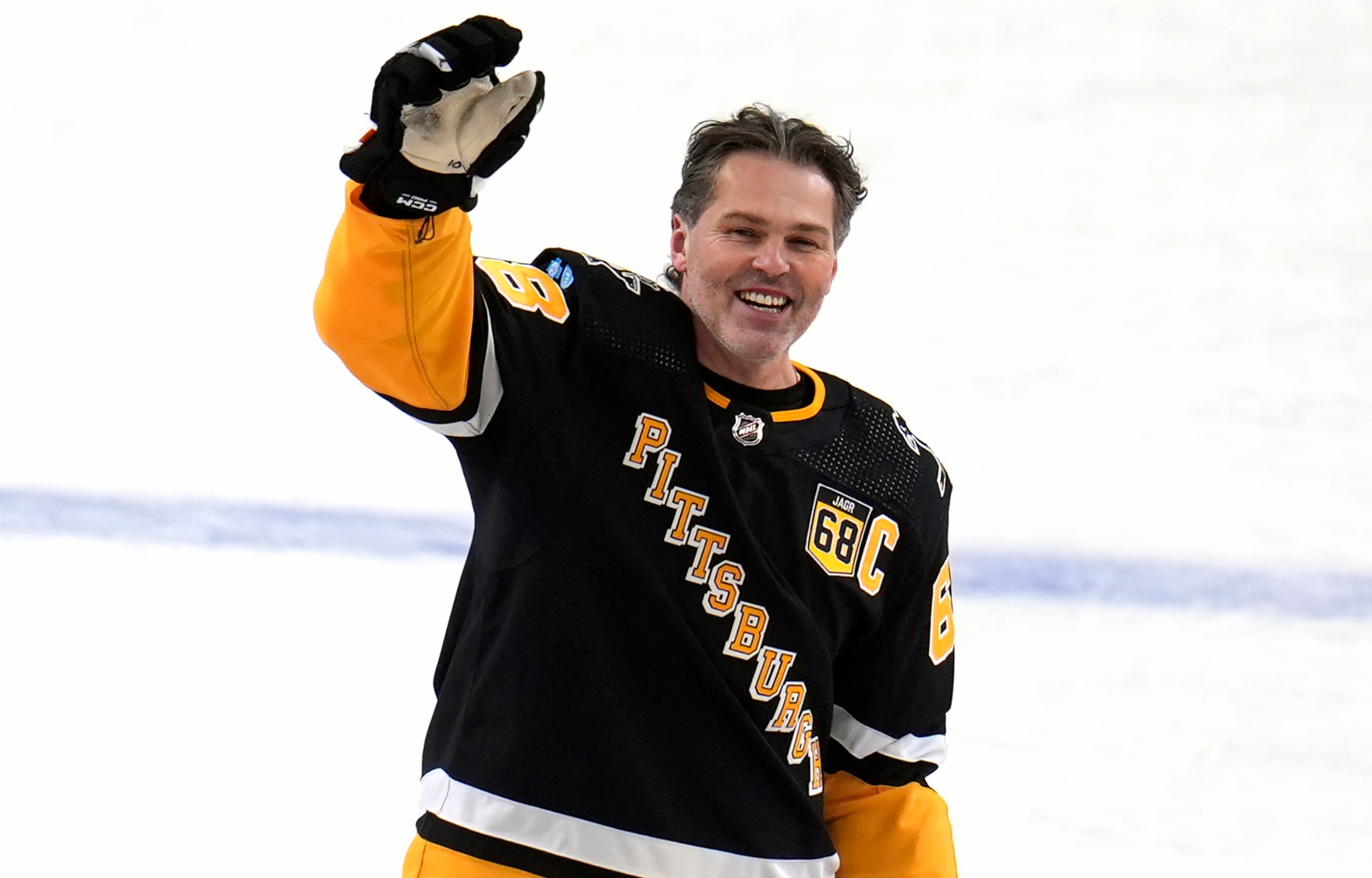 FILE - Former Pittsburgh Penguins player Jaromir Jagr stands at center ice and waves to fans after skating during warm ups after having a banner with his retired uniform number raised to the rafters of PPG Paints arena before an NHL hockey game between the Los Angeles Kings and the Penguins in Pittsburgh, Sunday, Feb. 18, 2024. (AP Photo/Gene Puskar, File)