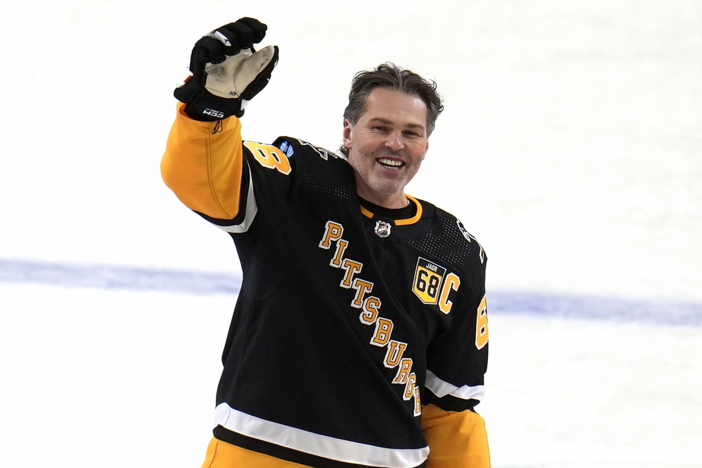 FILE - Former Pittsburgh Penguins player Jaromir Jagr stands at center ice and waves to fans after skating during warm ups after having a banner with his retired uniform number raised to the rafters of PPG Paints arena before an NHL hockey game between the Los Angeles Kings and the Penguins in Pittsburgh, Sunday, Feb. 18, 2024. (AP Photo/Gene Puskar, File)