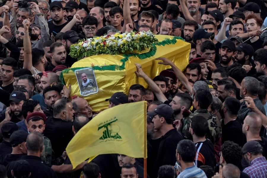 Mourners carry the coffin of Mohammed Mahdi, son of Hezbollah legislator Ali Ammar, who was killed Tuesday after his handheld pager exploded, in the southern suburb of Beirut, Lebanon, Wednesday, Sept. 18, 2024. (AP Photo/Bilal Hussein)