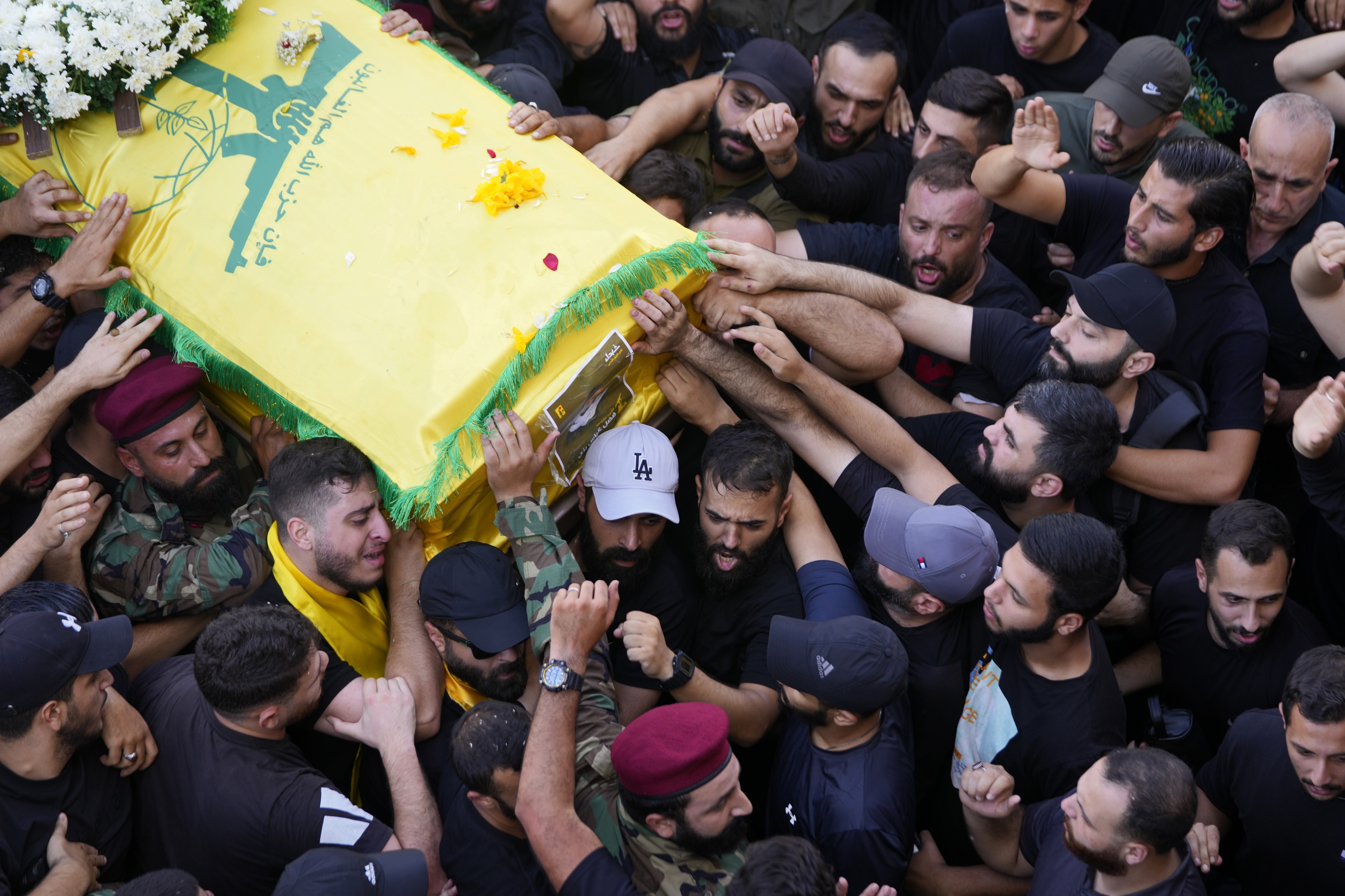 Hezbollah members carry the coffin of their comrade who was killed on Wednesday when a handheld device exploded, during a funeral procession in the southern suburbs of Beirut, Thursday, Sept. 19, 2024. (AP Photo/Hussein Malla)