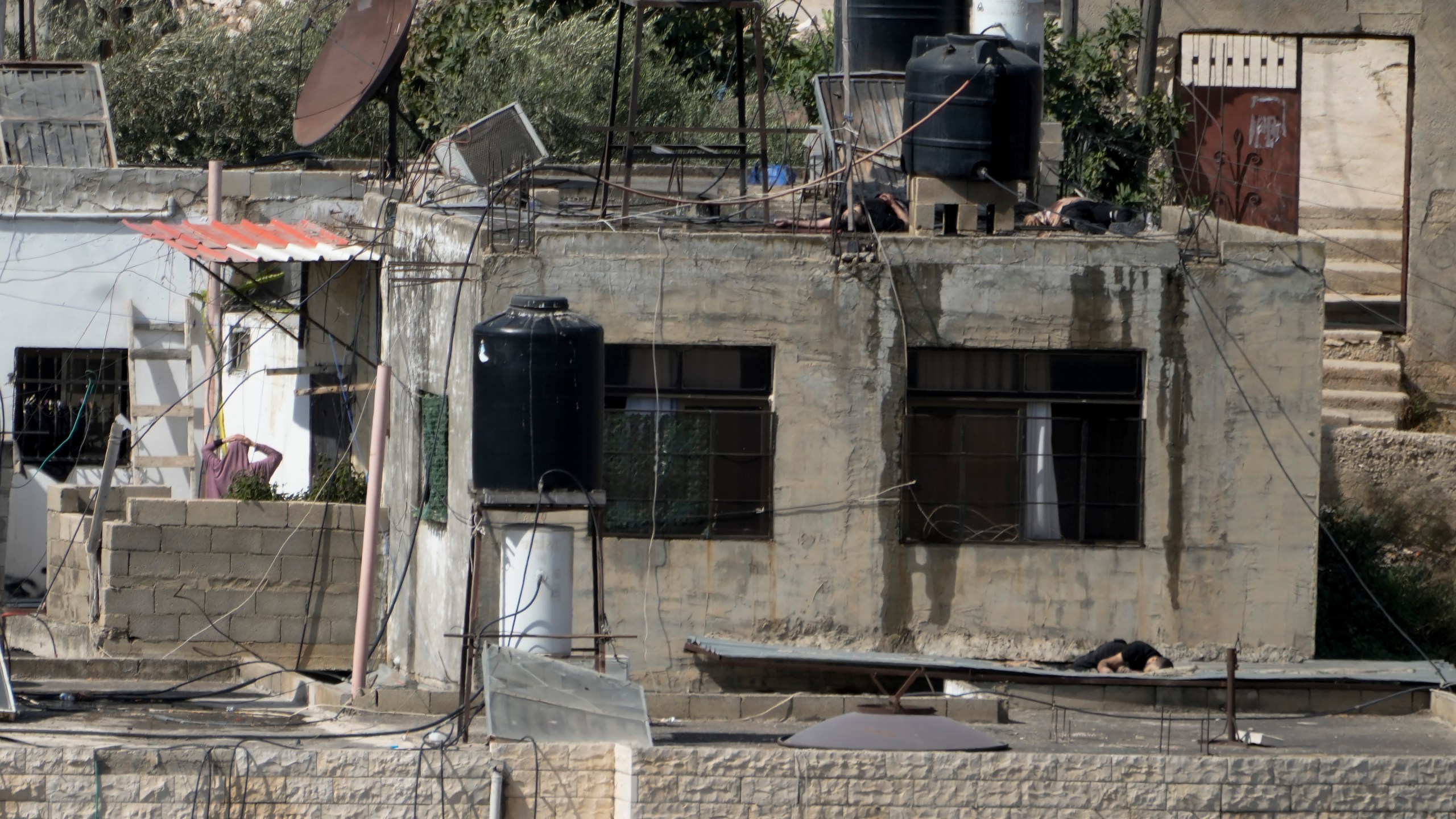 EDS NOTE: GRAPHIC CONTENT - Three bodies lie motionless on rooftops in the West Bank town of Qabatiya during a Israeli raid, Thursday, Sept. 19, 2024. (AP Photo/Majdi Mohammed)