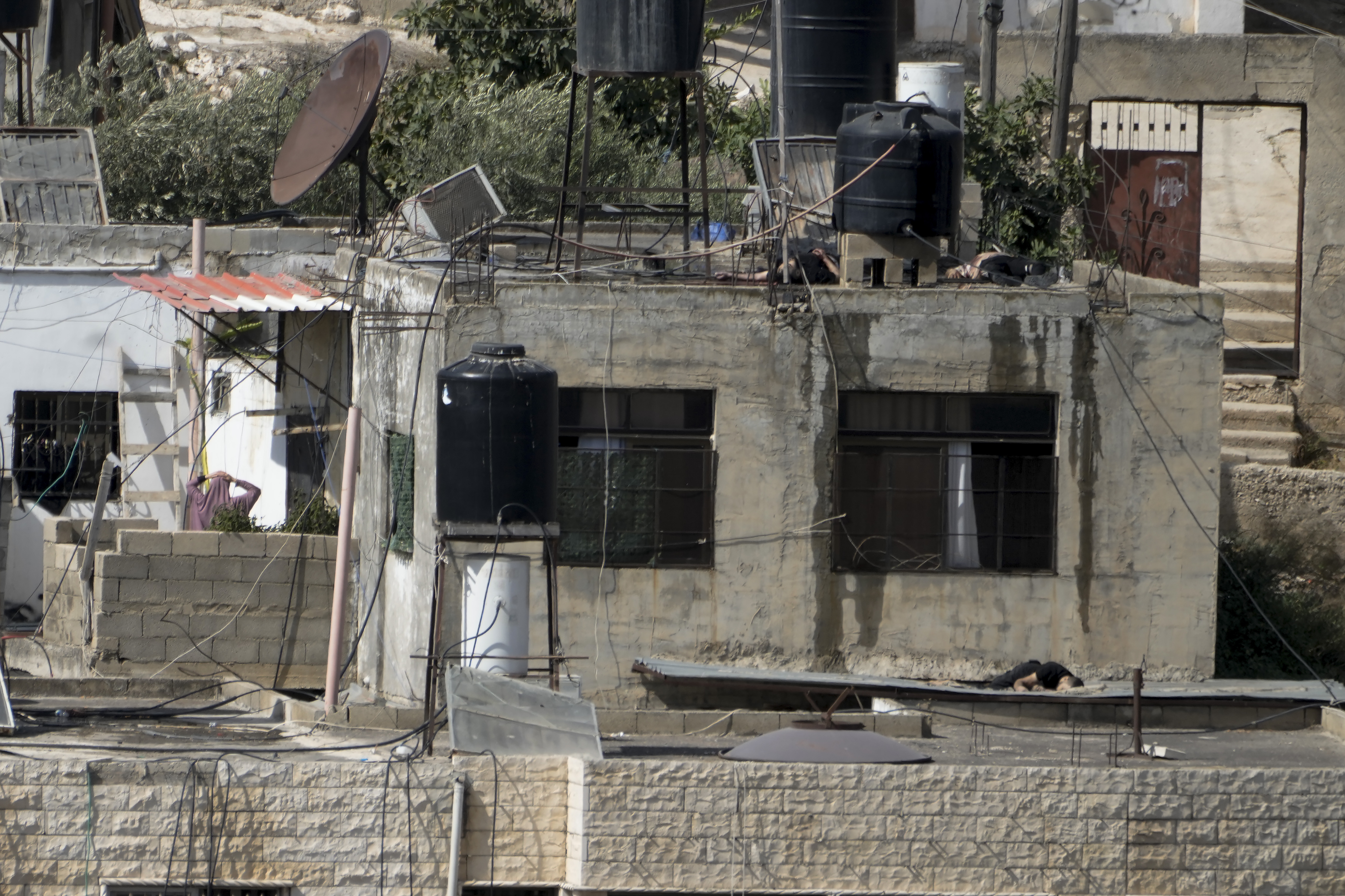 EDS NOTE: GRAPHIC CONTENT - Three bodies lie motionless on rooftops in the West Bank town of Qabatiya during a Israeli raid, Thursday, Sept. 19, 2024. (AP Photo/Majdi Mohammed)