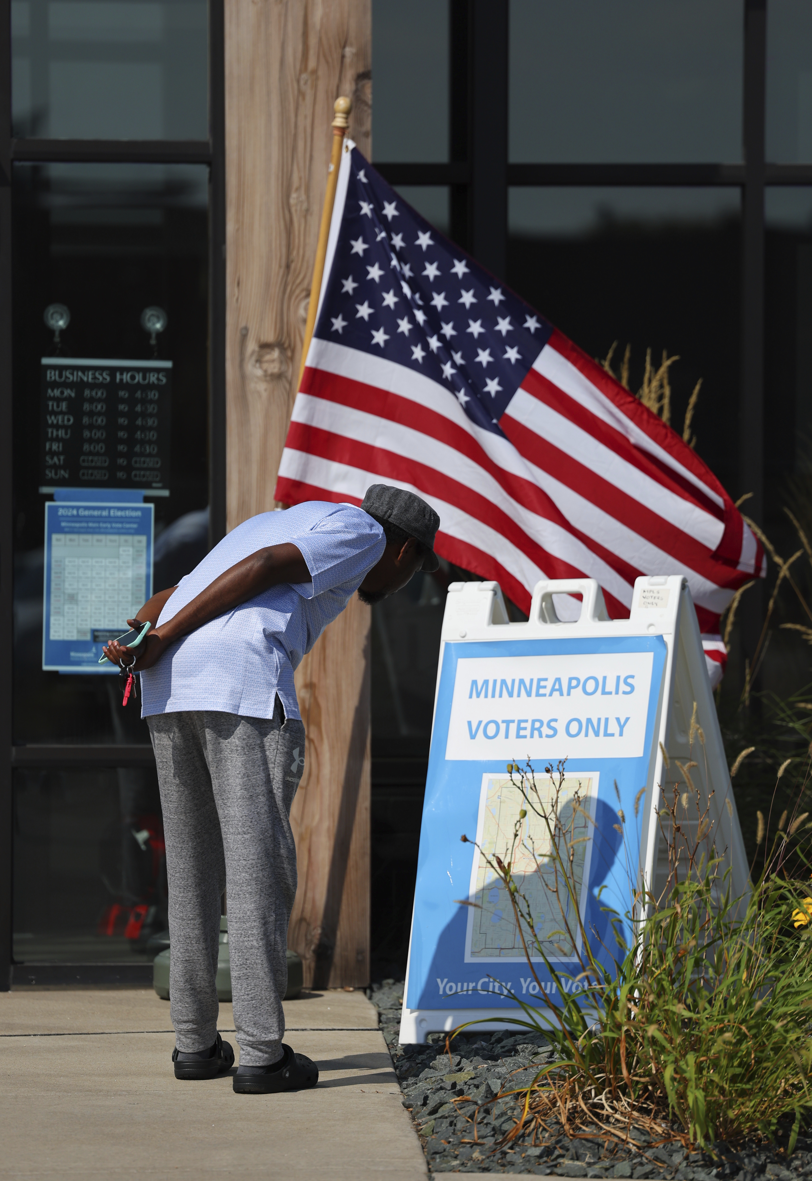 A member of the public looks at a Minneapolis map outside of the City of Minneapolis early voting center, Thursday, Sept. 19, 2024, in St. Paul, Minn. In-person voting in the 2024 presidential contest begins Friday in three states, including Democratic vice presidential candidate Tim Walz's home state of Minnesota, with just over six weeks left before Election Day. (AP Photo/Adam Bettcher)