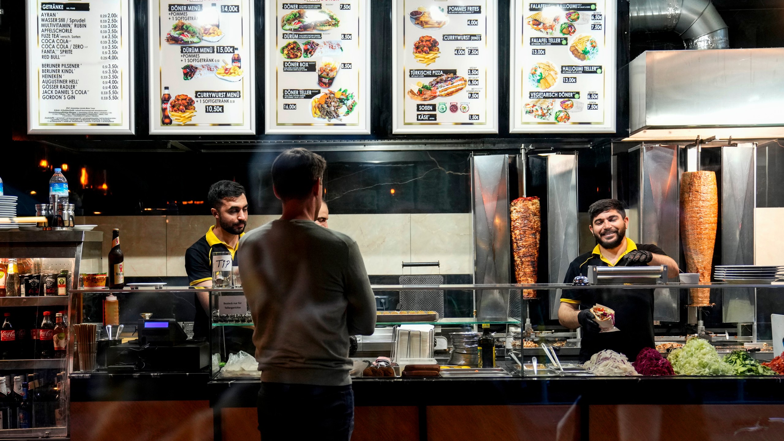 Turkish doner cooks prepare doner kebabs for customers in a doner kebab restaurant in Berlin, Germany, Wednesday, Sept. 18, 2024. (AP Photo/Ebrahim Noroozi)