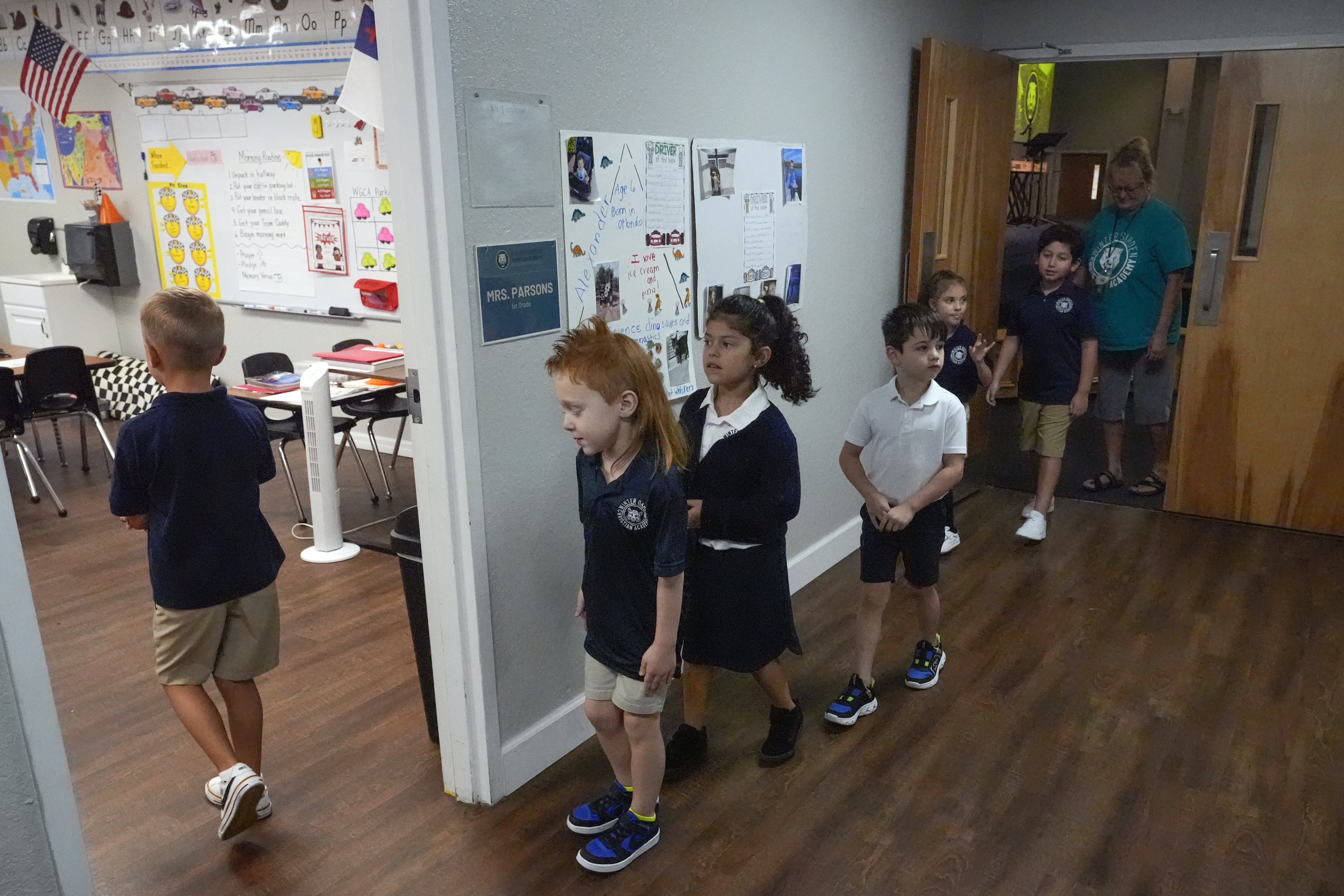 First grade students return to the classroom after a chapel service at the Winter Garden Christian Academy, Thursday, Aug. 29, 2024, in Winter Garden, Fla. (AP Photo/John Raoux)