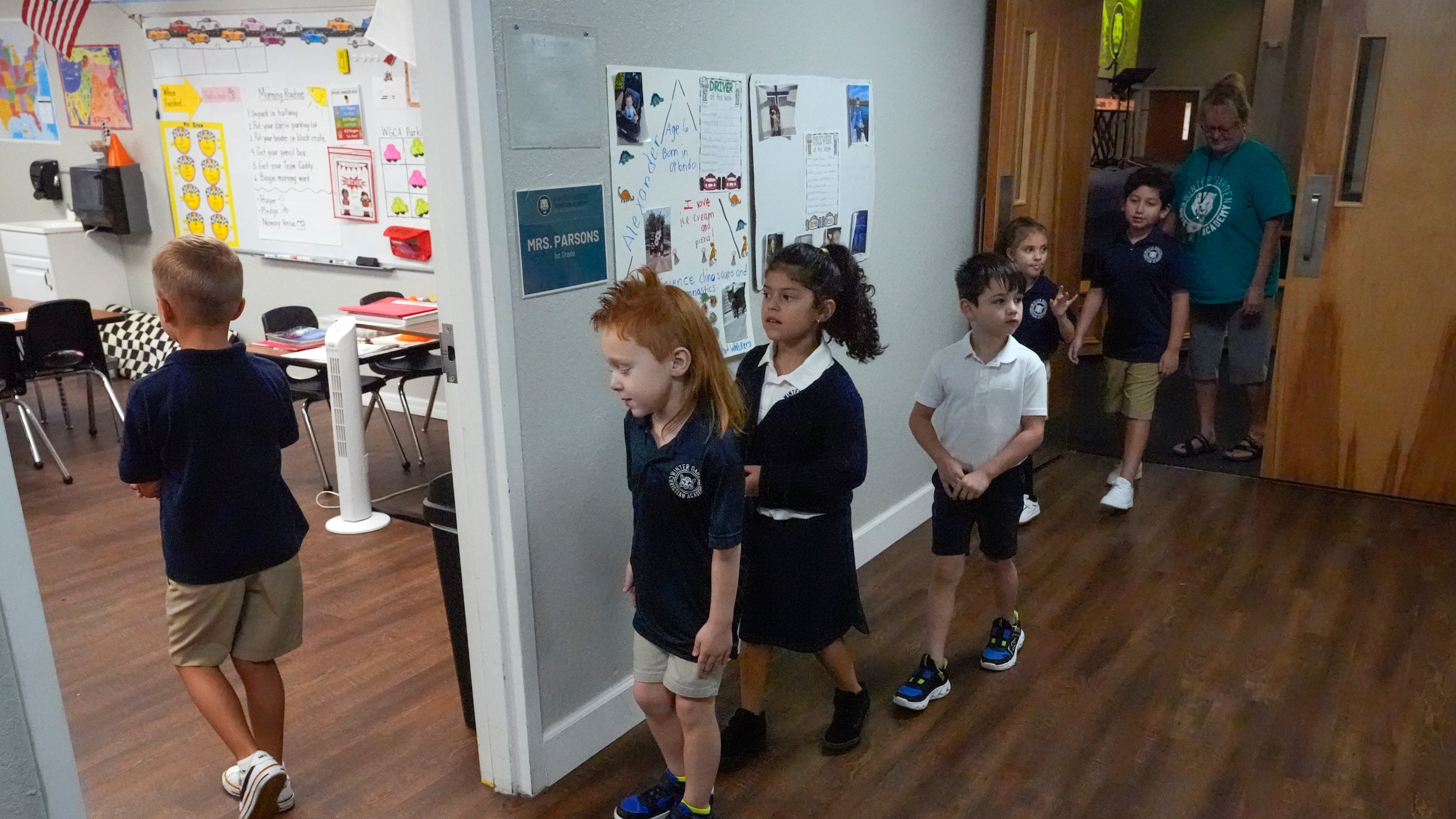 First grade students return to the classroom after a chapel service at the Winter Garden Christian Academy, Thursday, Aug. 29, 2024, in Winter Garden, Fla. (AP Photo/John Raoux)