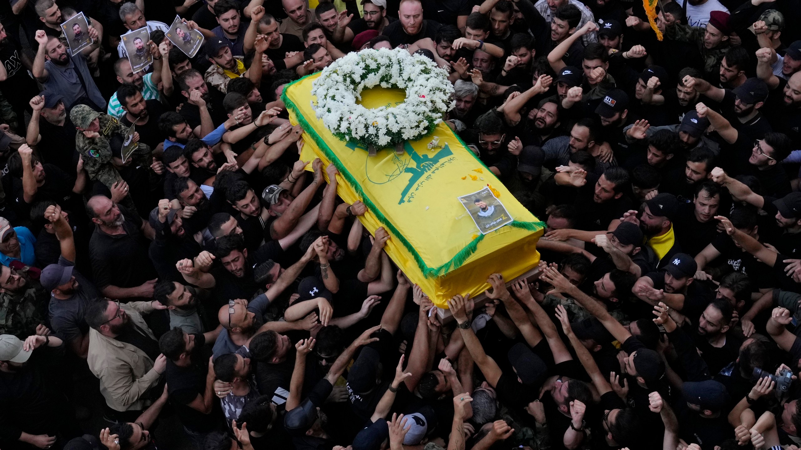 Hezbollah members carry the coffin of their comrade who was killed when a handheld device exploded, during a funeral procession in the southern suburbs of Beirut, Thursday, Sept. 19, 2024. (AP Photo/Hussein Malla)