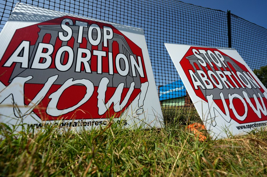 Anti-abortion signs lean agains a fence outside a recently opened Planned Parenthood clinic in Pittsburg, Kan., Tuesday, Sept. 10, 2024. (AP Photo/Charlie Riedel)