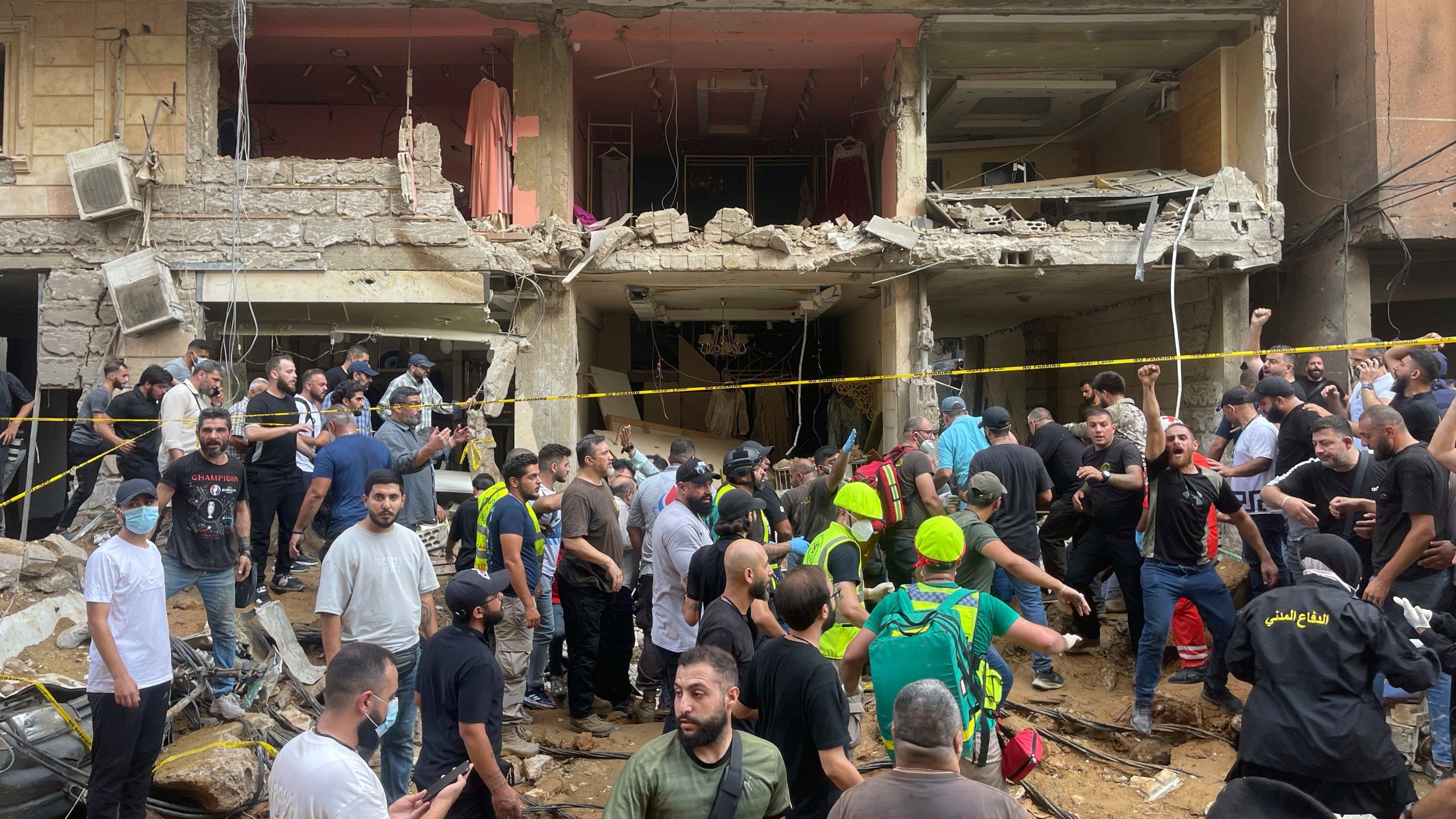 People gather near a damaged building at the scene of an Israeli missile strike in the southern suburbs of Beirut, Friday, Sept. 20, 2024. (AP Photo/Bilal Hussein)