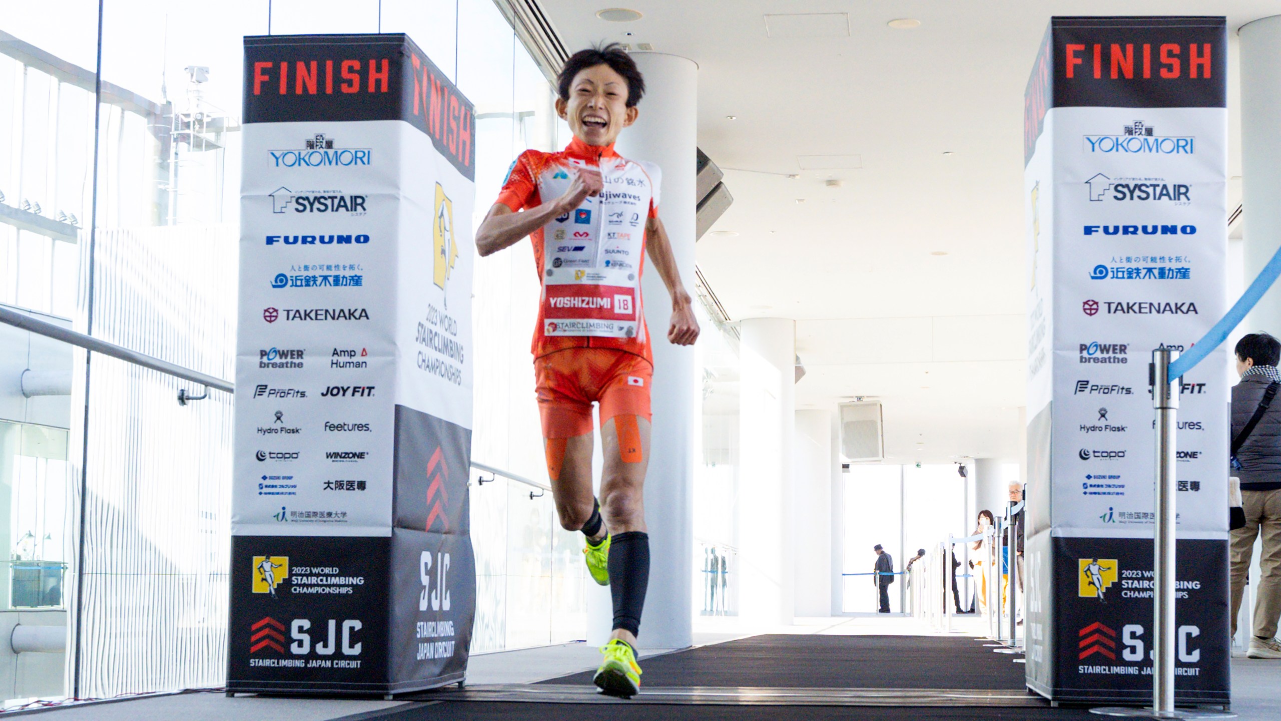 In this photo provided by ISF/Meeting, runner Yuri Yoshizumi crosses the finish line during a race of Stairclimbing World Championships on Nov. 19, 2023 in Osaka, western Japan. (ISF/MEETING via AP)