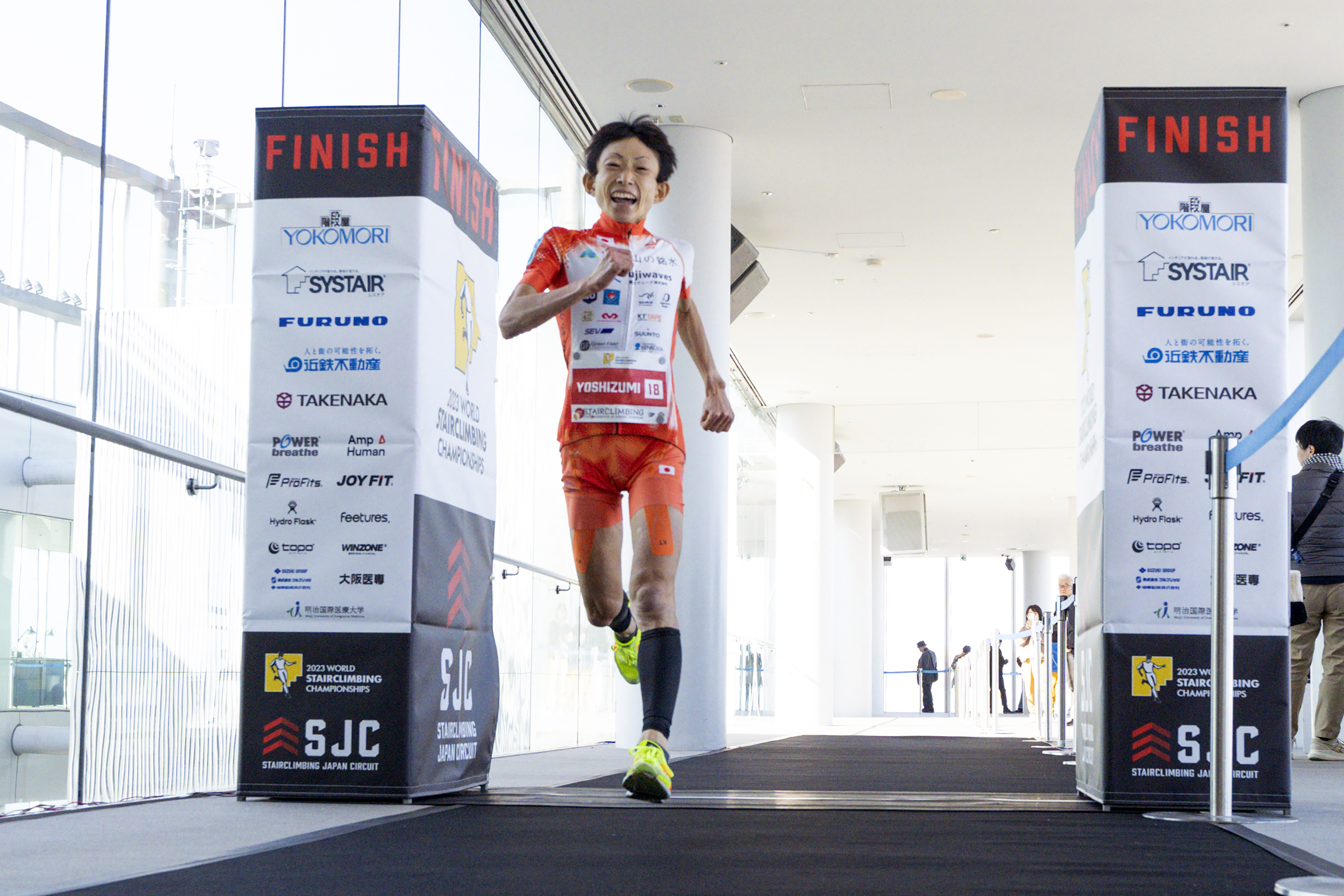 In this photo provided by ISF/Meeting, runner Yuri Yoshizumi crosses the finish line during a race of Stairclimbing World Championships on Nov. 19, 2023 in Osaka, western Japan. (ISF/MEETING via AP)