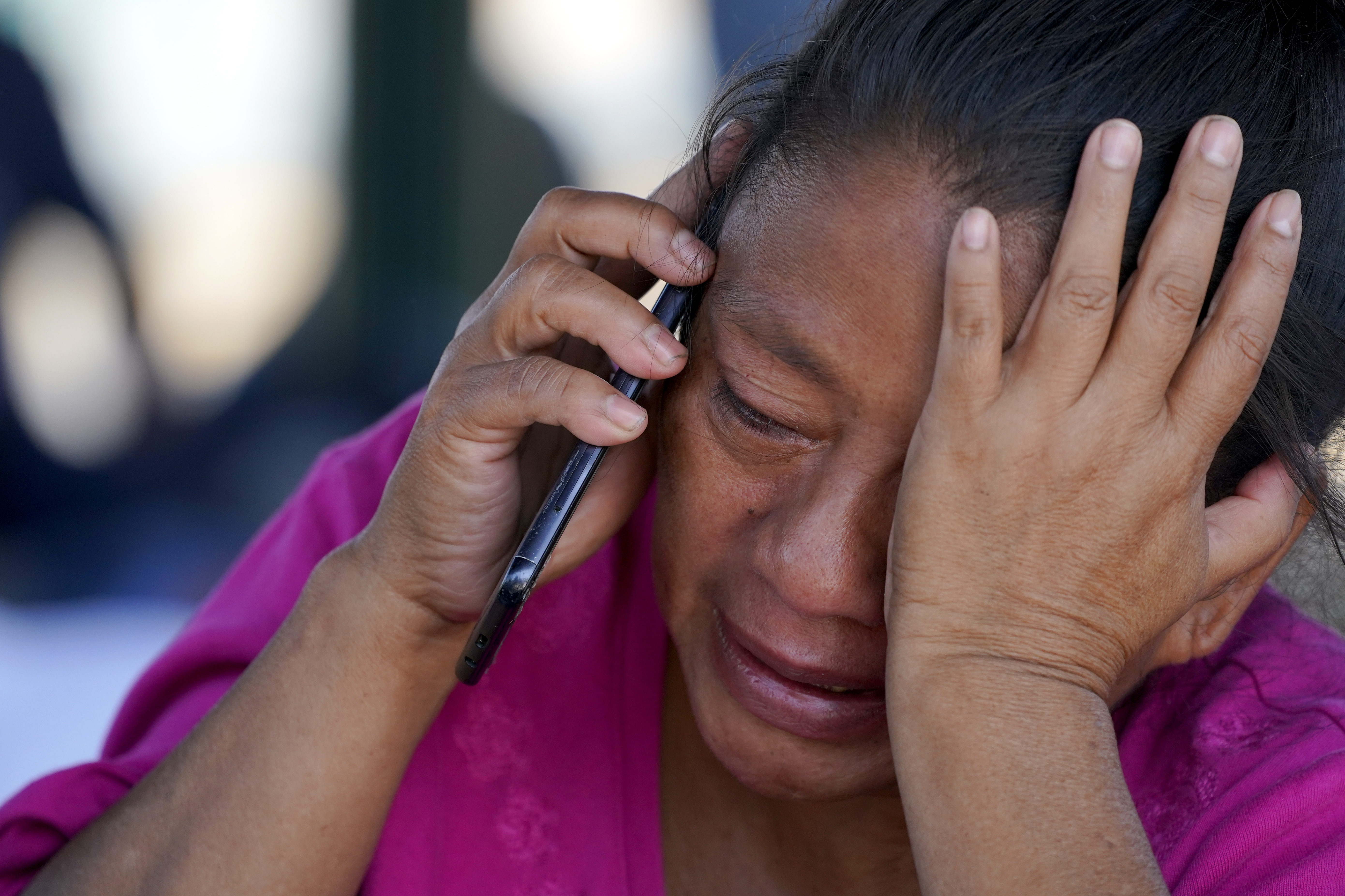 FILE - A migrant woman cries as she talks on a cellphone at a park after she and a large group of deportees from the U.S. were pushed by Mexican authorities off an area they had been staying after their expulsion, Saturday, March 20, 2021, in Reynosa, Mexico. (AP Photo/Julio Cortez)