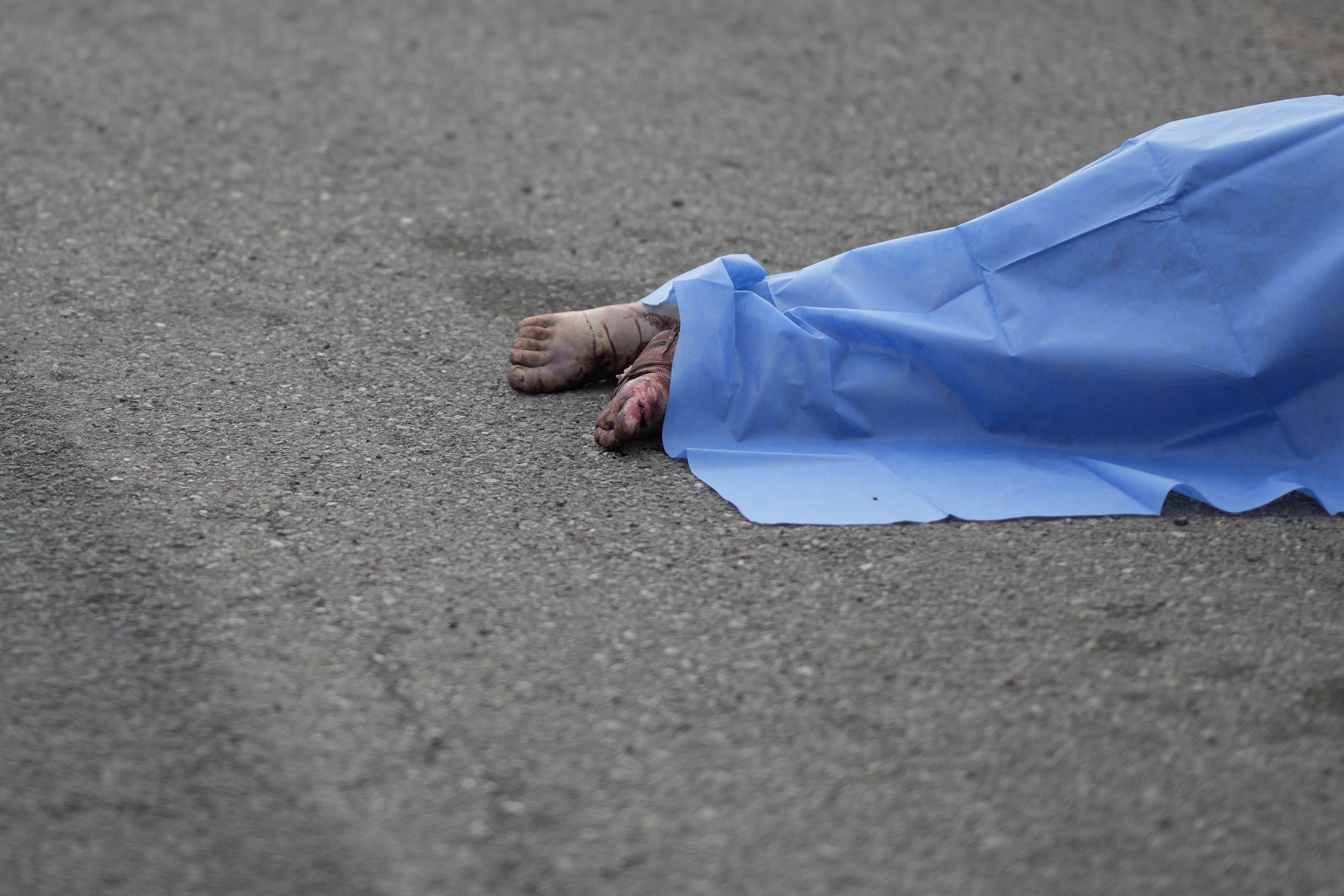 A blue sheet covers a body found lying on the side of a road in Culiacan, Sinaloa state, Mexico, Saturday, Sept. 21, 2024. (AP Photo/Eduardo Verdugo)