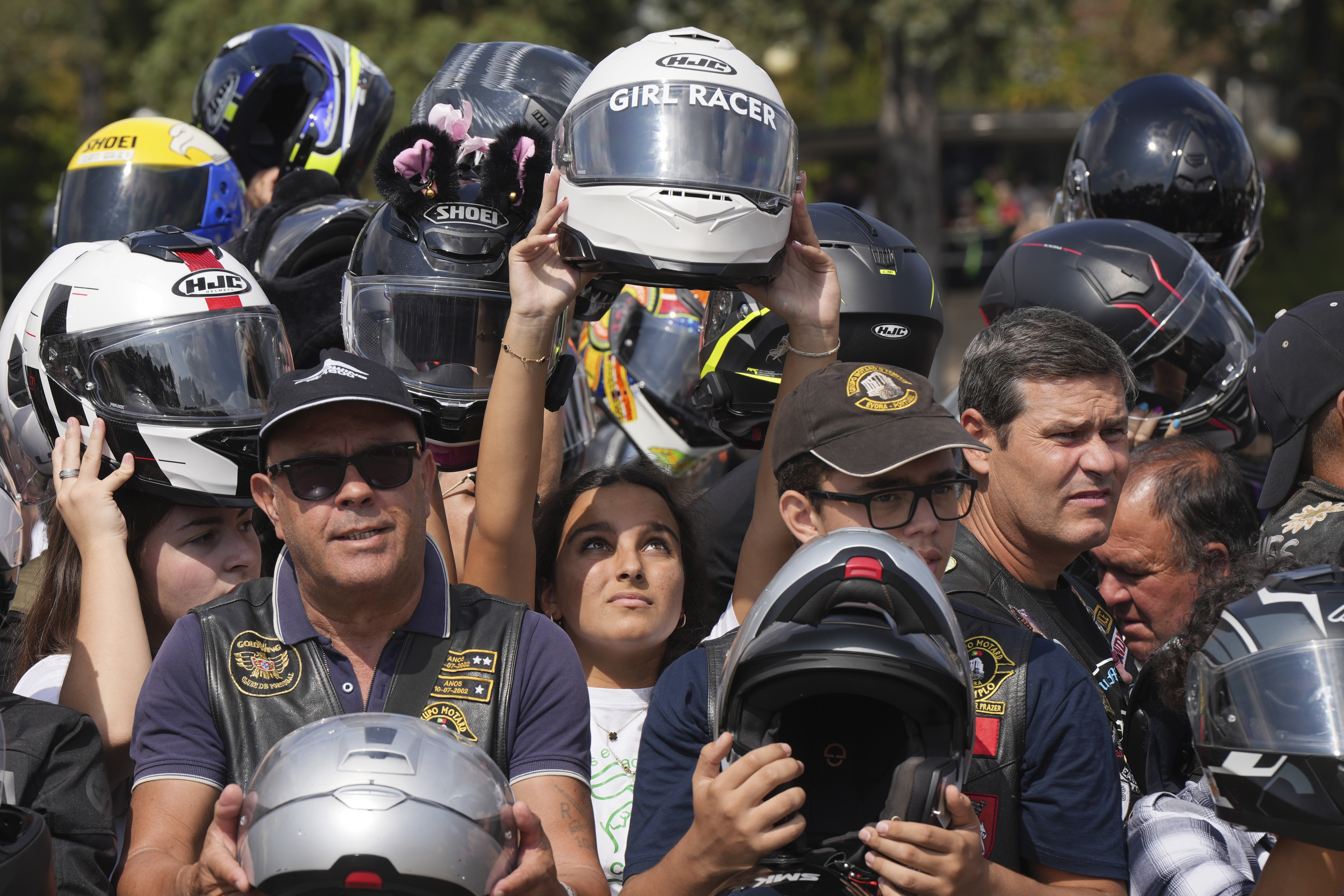 Faithful hold up their helmets to be blessed during the IX Pilgrimage of the Blessing of Helmets that draws tens of thousands at the Roman Catholic holy shrine of Fatima, in Fatima, Portugal, Sunday, Sept. 22, 2024. (AP Photo/Ana Brigida)