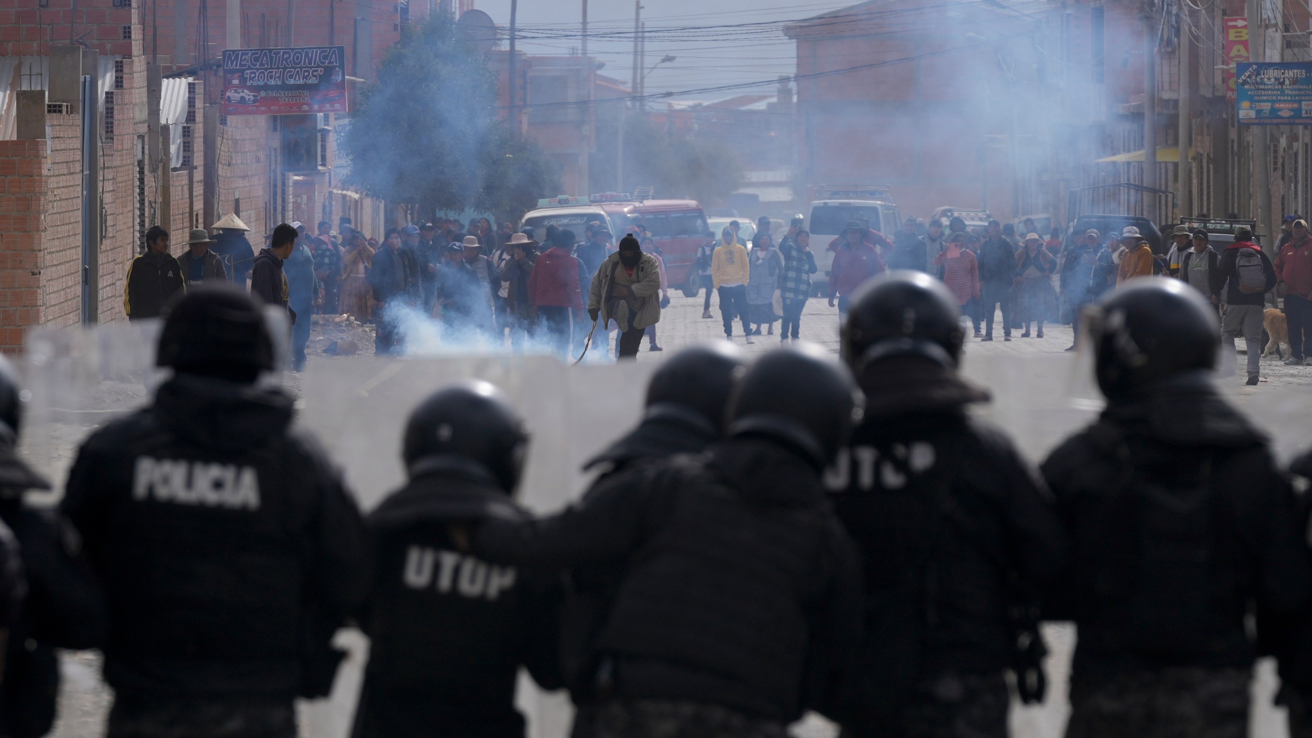 Police stand in front of supporters of former President Evo Morales in El Alto, Bolivia, Sunday, Sept. 22, 2024. (AP Photo/Juan Karita)