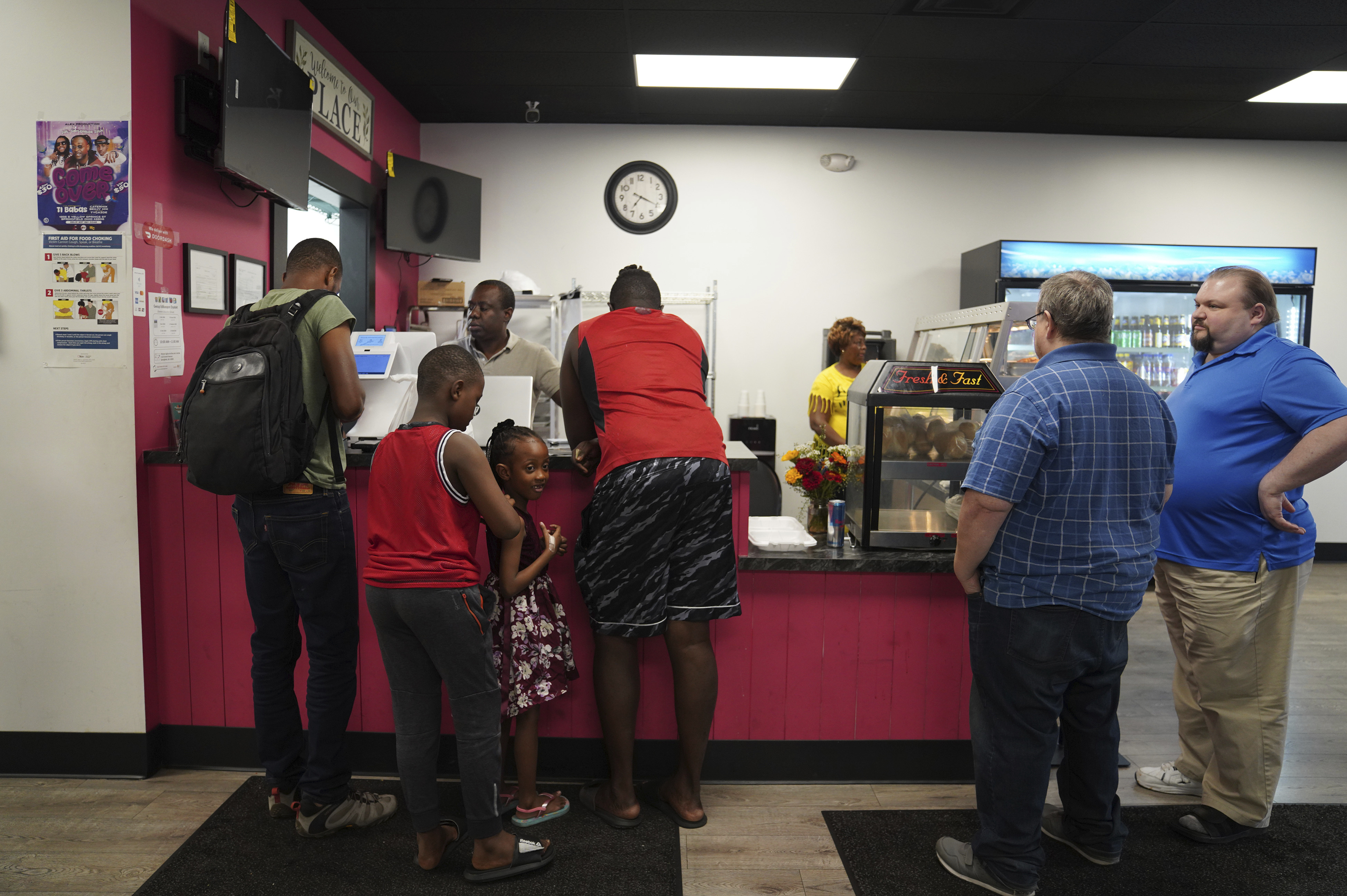 Romane Pierre of Rose Goute Creole Restaurant in Springfield, Ohio, helps a line of customers, Monday, Sept. 16, 2024. (AP Photo/Jessie Wardarski)