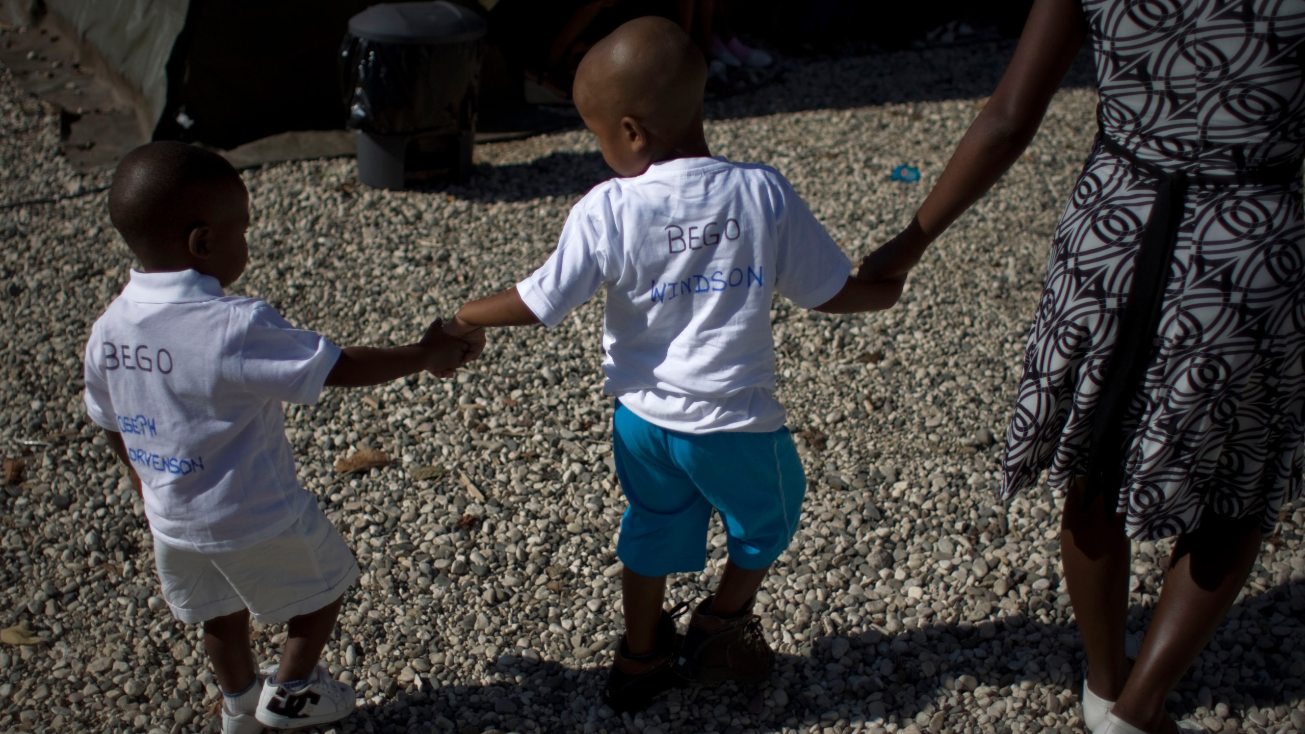 FILE - Haitian children walk hand in hand as they await the arrival of their adoptive parents in Port-au-Prince, Haiti, Dec. 21, 2010. (AP Photo/Ramon Espinosa, File)