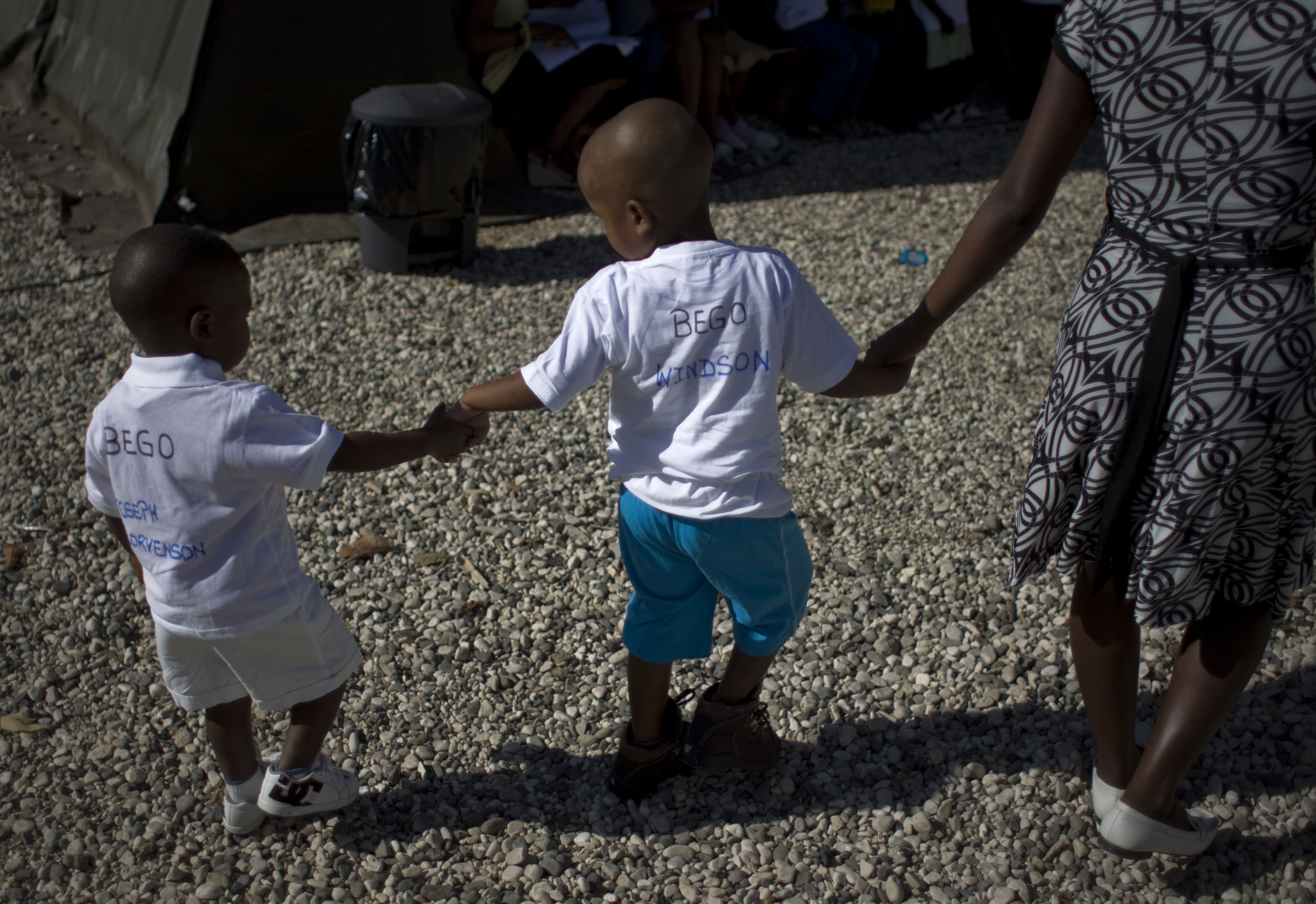 FILE - Haitian children walk hand in hand as they await the arrival of their adoptive parents in Port-au-Prince, Haiti, Dec. 21, 2010. (AP Photo/Ramon Espinosa, File)