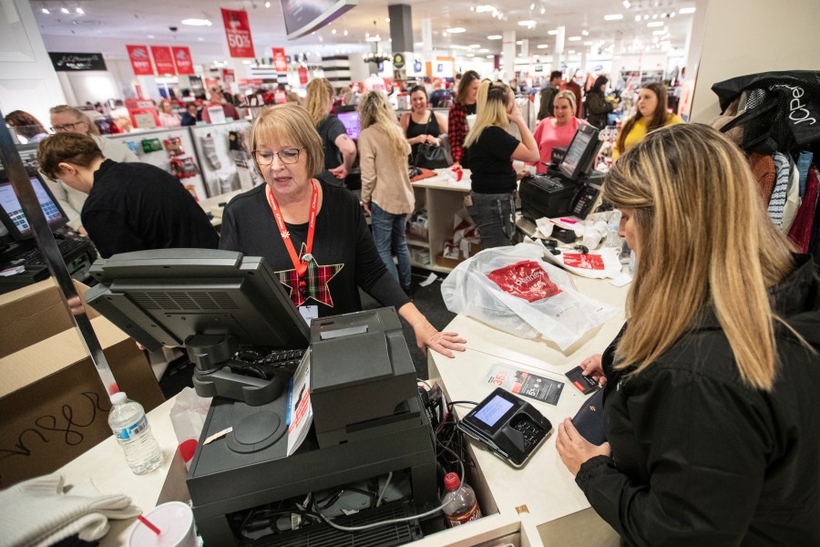 FILE - Terri Ross, left, checks out a customer at a store in the Huntington Mall on Nov. 25, 2022, in Barboursville, W.Va. (Sholten Singer/The Herald-Dispatch via AP, File)