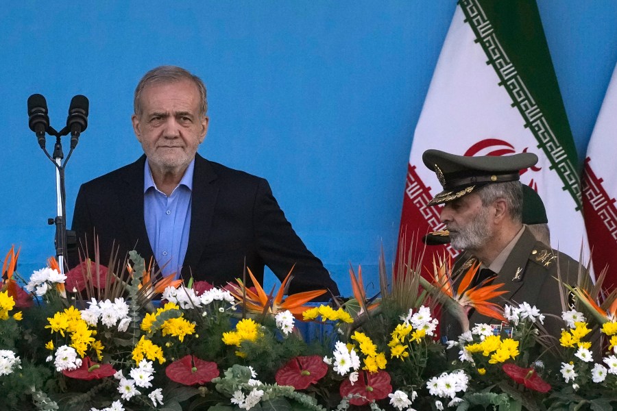 Iranian President Masoud Pezeshkian, left, arrives at the podium, accompanied by the army commander Gen. Abdolrahim Mousavi during an annual armed forces parade marking anniversary of the beginning of war against Iran by former Iraqi Dictator Saddam Hussein 44 years ago, in front of the shrine of the late revolutionary founder Ayatollah Khomeini, just outside Tehran, Iran, Saturday, Sept. 21, 2024. (AP Photo/Vahid Salemi)