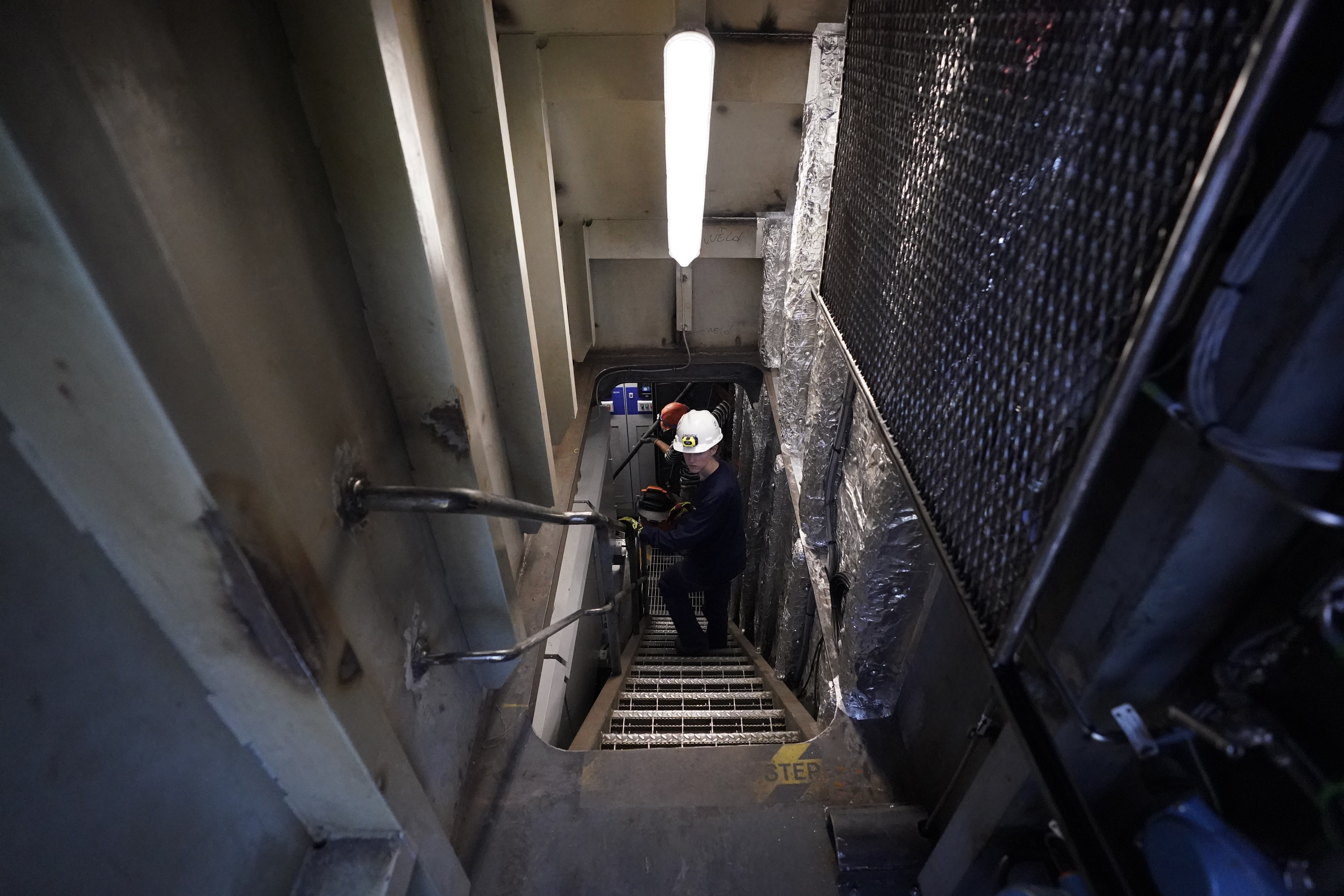 Abigail Jablansky, head of project management, walks down the stairs on the NH3 Kraken, a tugboat powered by ammonia, Friday, Sept. 13, 2024, in Kingston, N.Y. (AP Photo/Alyssa Goodman)