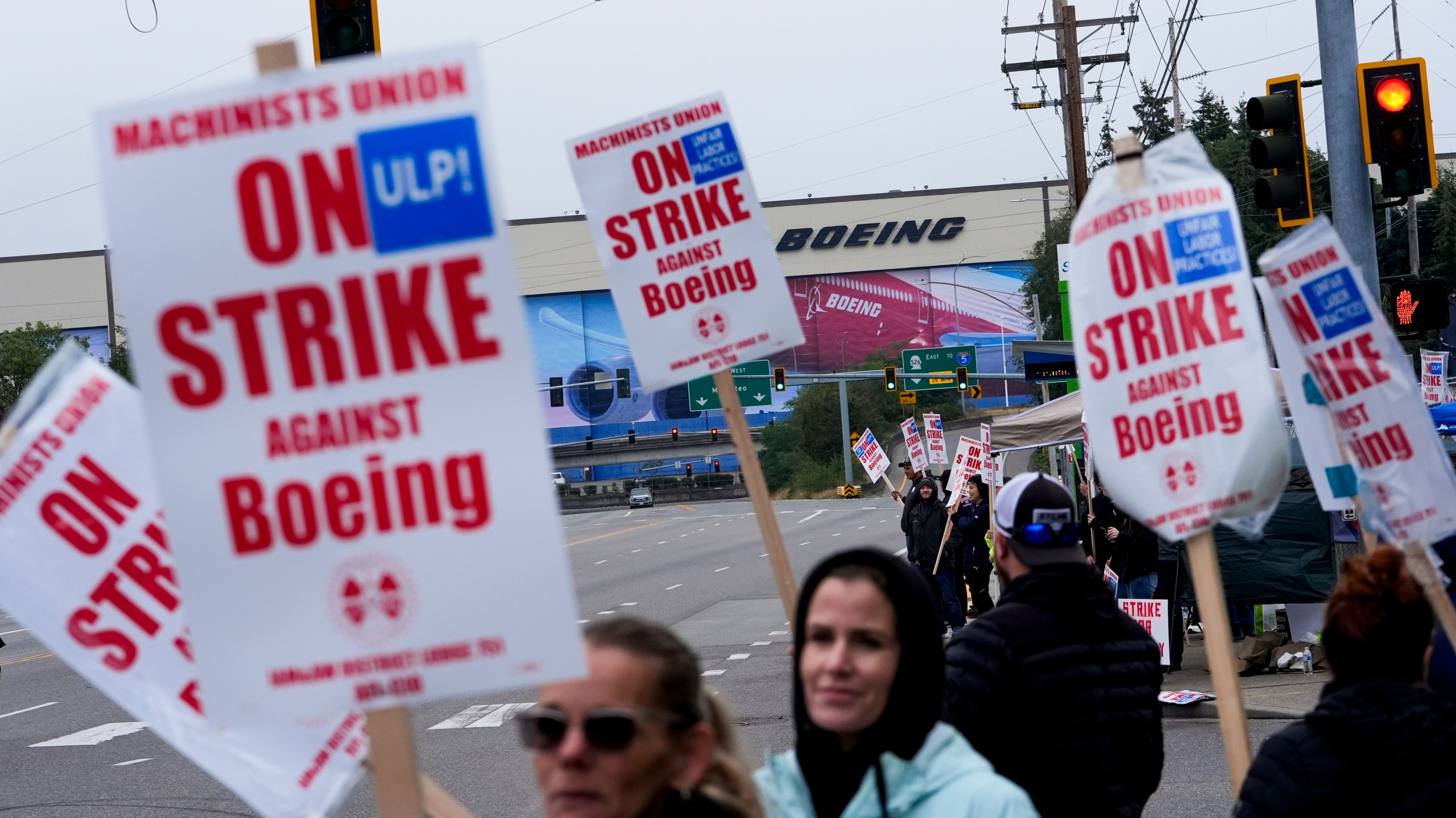 Boeing workers wave picket signs as they strike after union members voted to reject a contract offer, Sunday, Sept. 15, 2024, near the company's factory in Everett, Wash. (AP Photo/Lindsey Wasson)