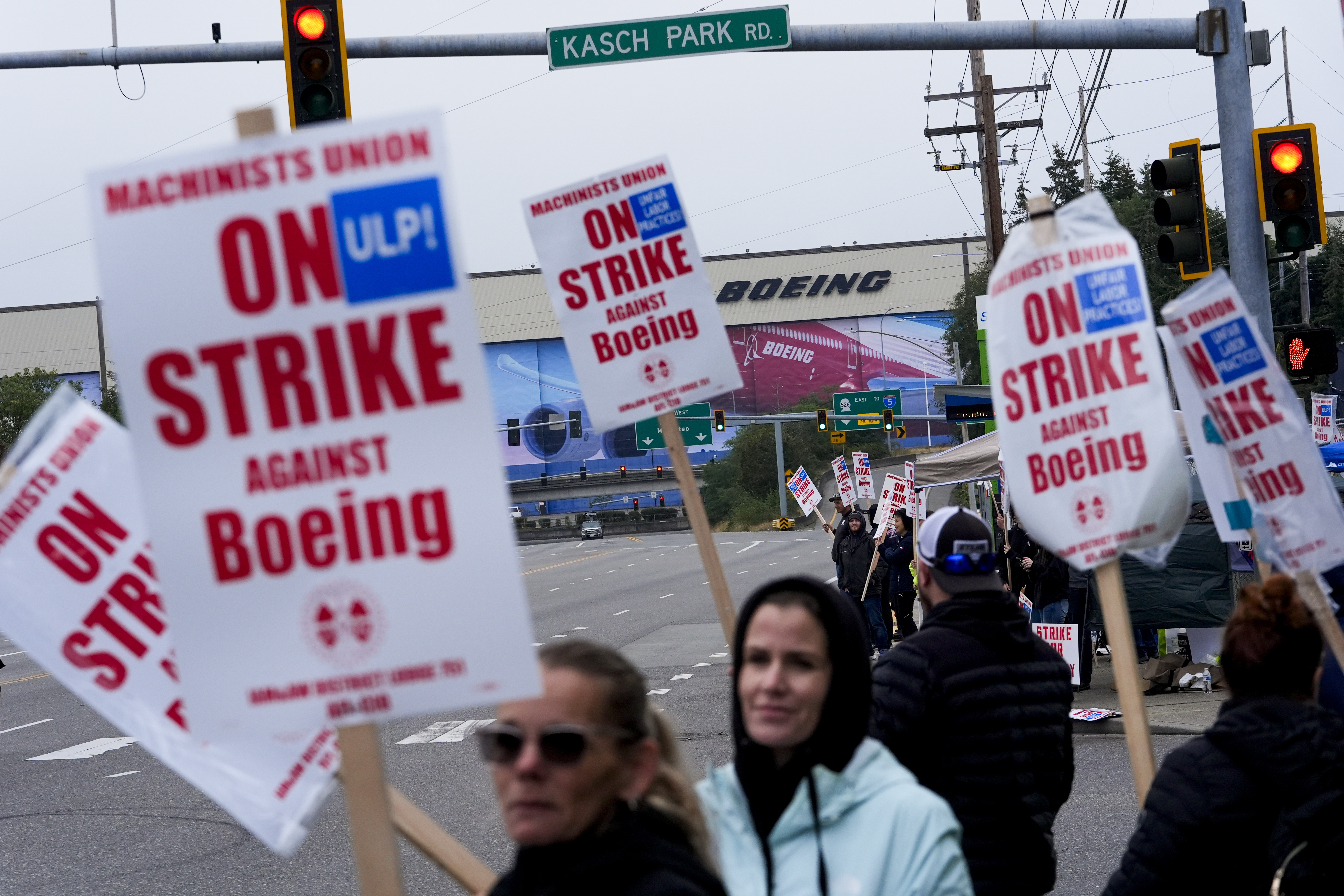 Boeing workers wave picket signs as they strike after union members voted to reject a contract offer, Sunday, Sept. 15, 2024, near the company's factory in Everett, Wash. (AP Photo/Lindsey Wasson)