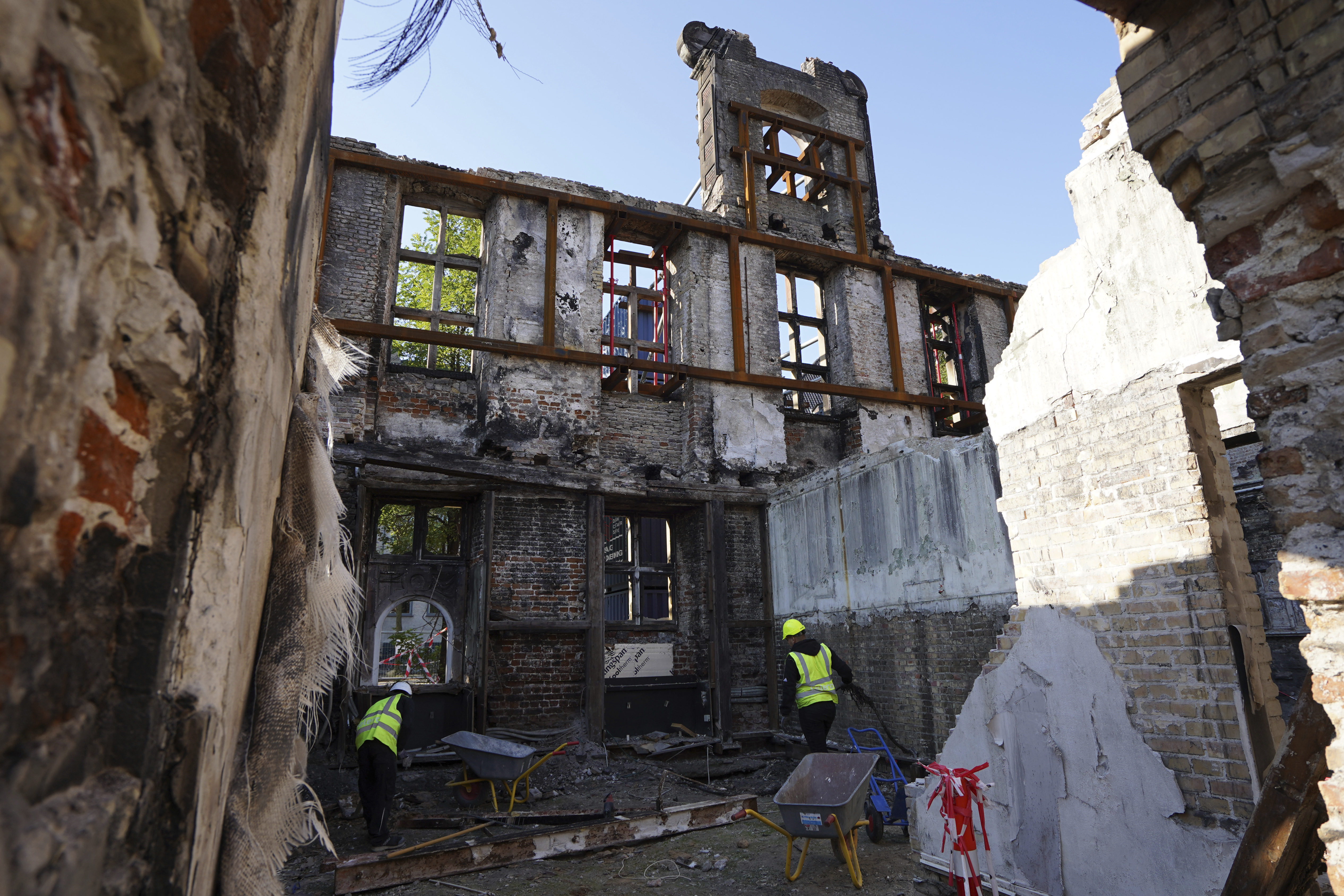 Workers clear rubble at Copenhagen's Old Stock Exchange building in Copenhagen, Denmark, Thursday, Sept. 19, 2024. (AP Photo James Brooks)