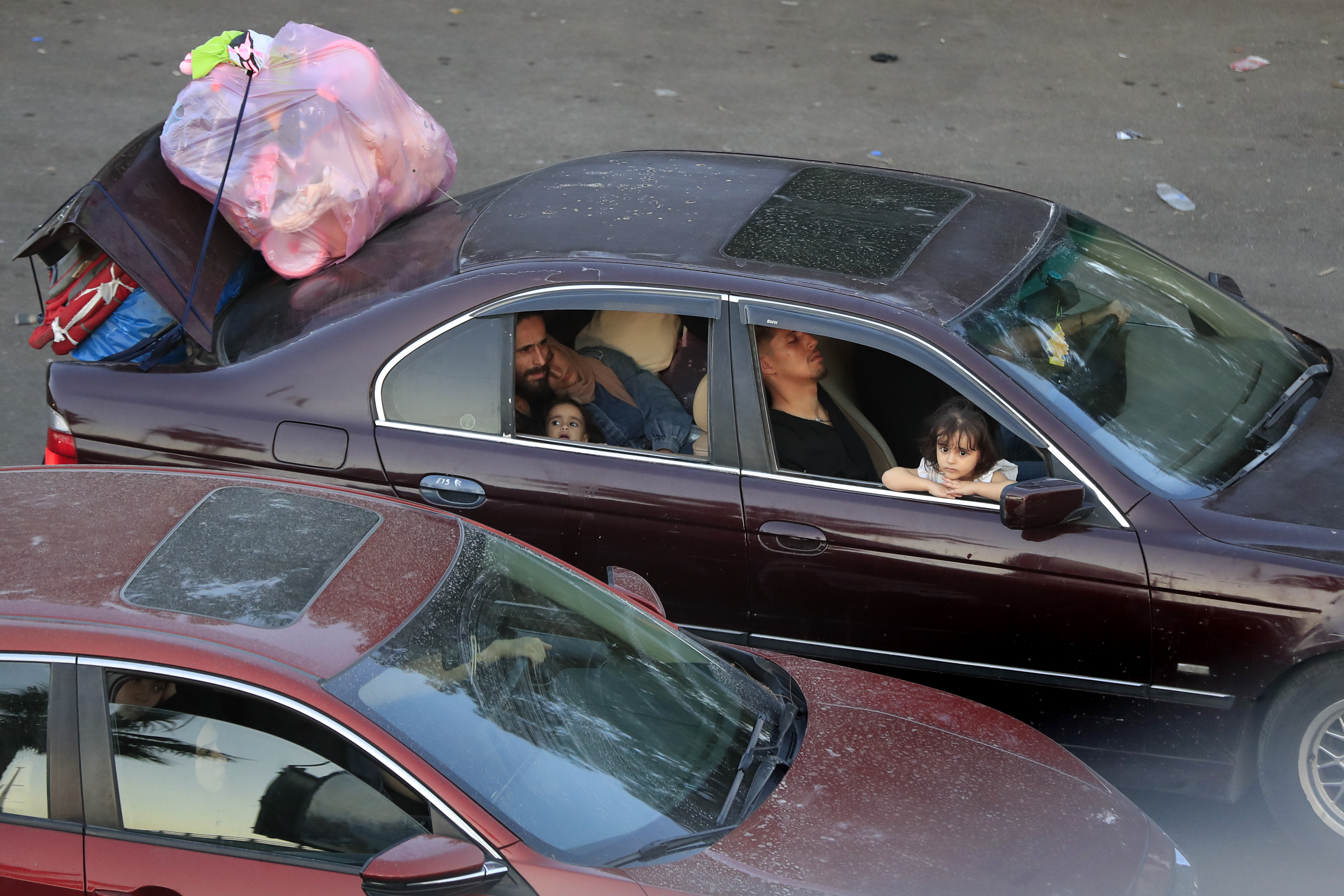 Lebanese citizens who fled the southern villages amid ongoing Israeli airstrikes Monday, sit in their cars at a highway that links to Beirut city, in the southern port city of Sidon, Lebanon, Tuesday, Sept. 24, 2024. (AP Photo/Mohammed Zaatari)