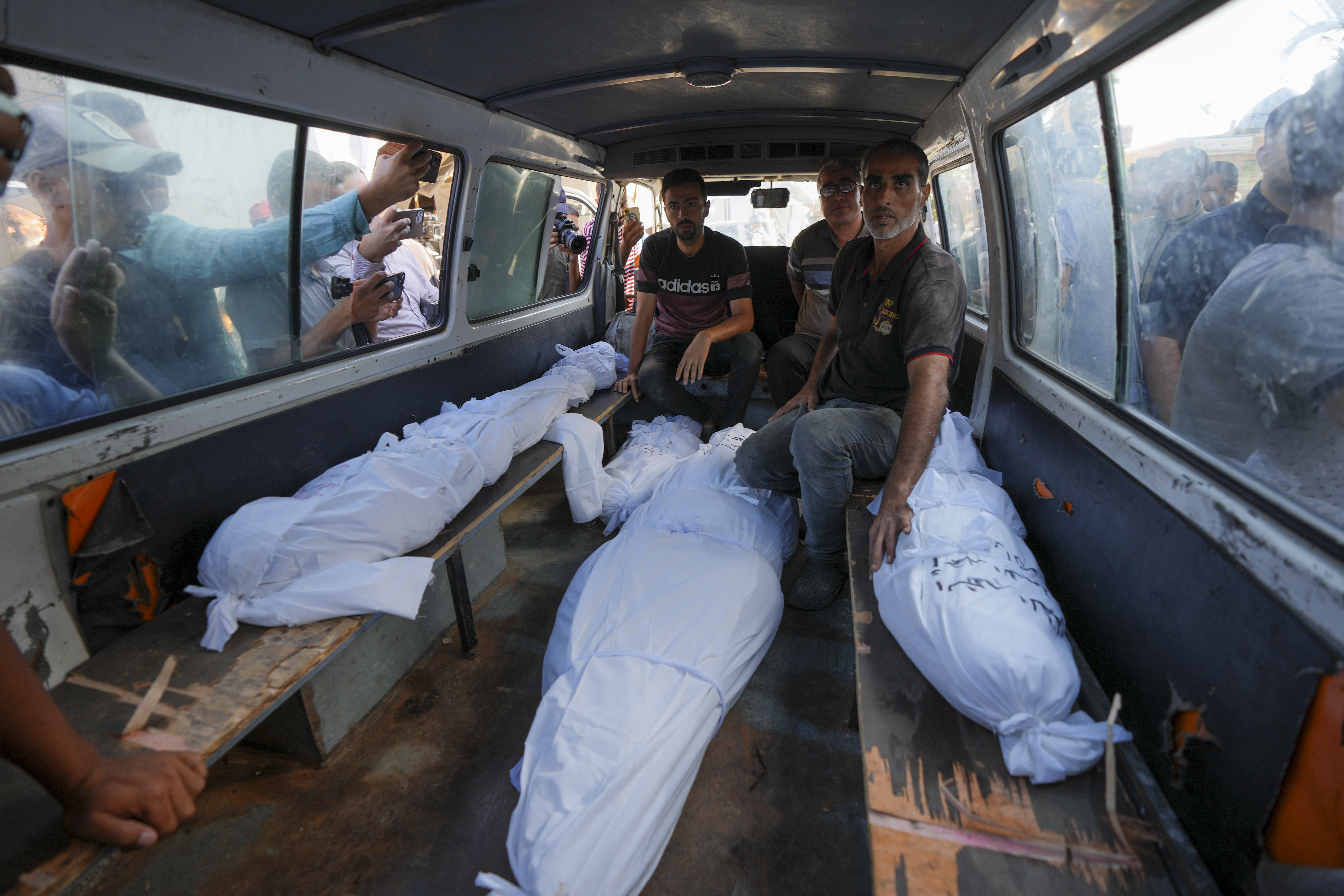 Mourners transport the bodies of their relatives killed in the Israeli bombardment of the Gaza Strip during their funeral in Deir al-Balah, Gaza, Monday, Sept. 23, 2024. (AP Photo/Abdel Kareem Hana)