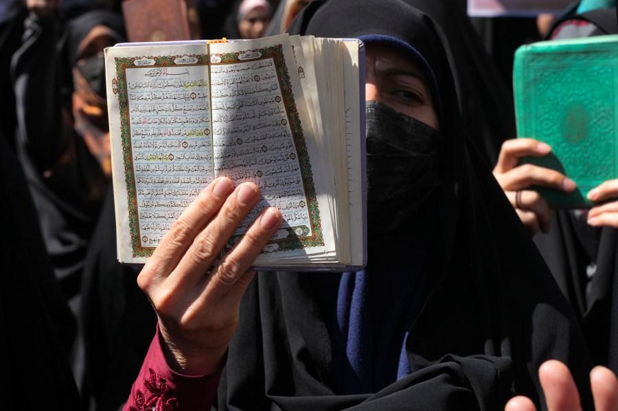 FILE -A demonstrator holds up a copy of the Quran, Islam's holy book, during a protest of the burning of a Quran in Sweden, in front of the Swedish Embassy in Tehran, Iran, June 30, 2023. (AP Photo/Vahid Salemi, File)