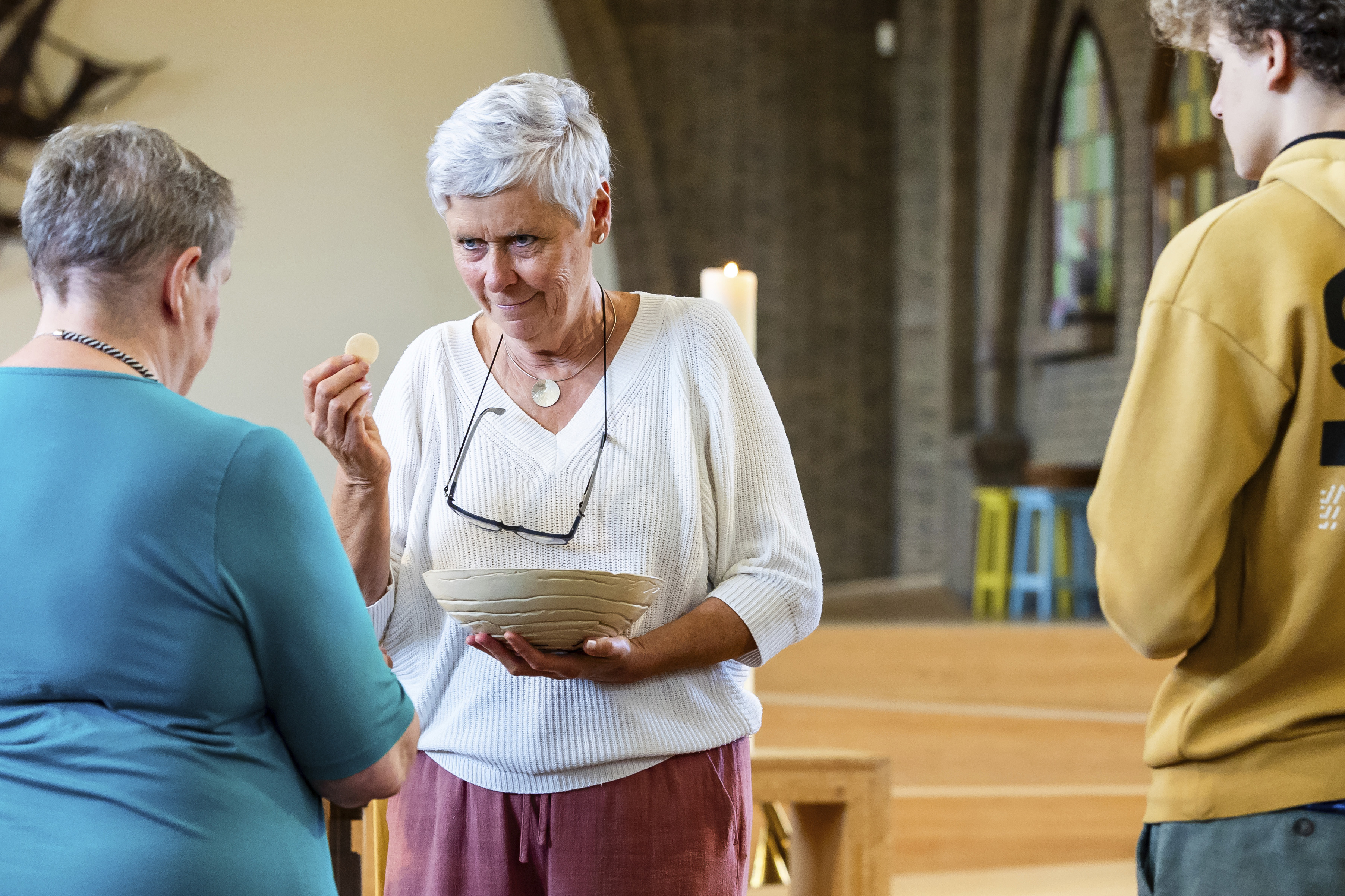 Laywoman Marijke Devaddere, center, hands over a host to a parishioner at the Don Bosco church in Buizingen, Belgium, Sunday, Sept. 8, 2024. (AP Photo/Geert Vanden Wijngaert)