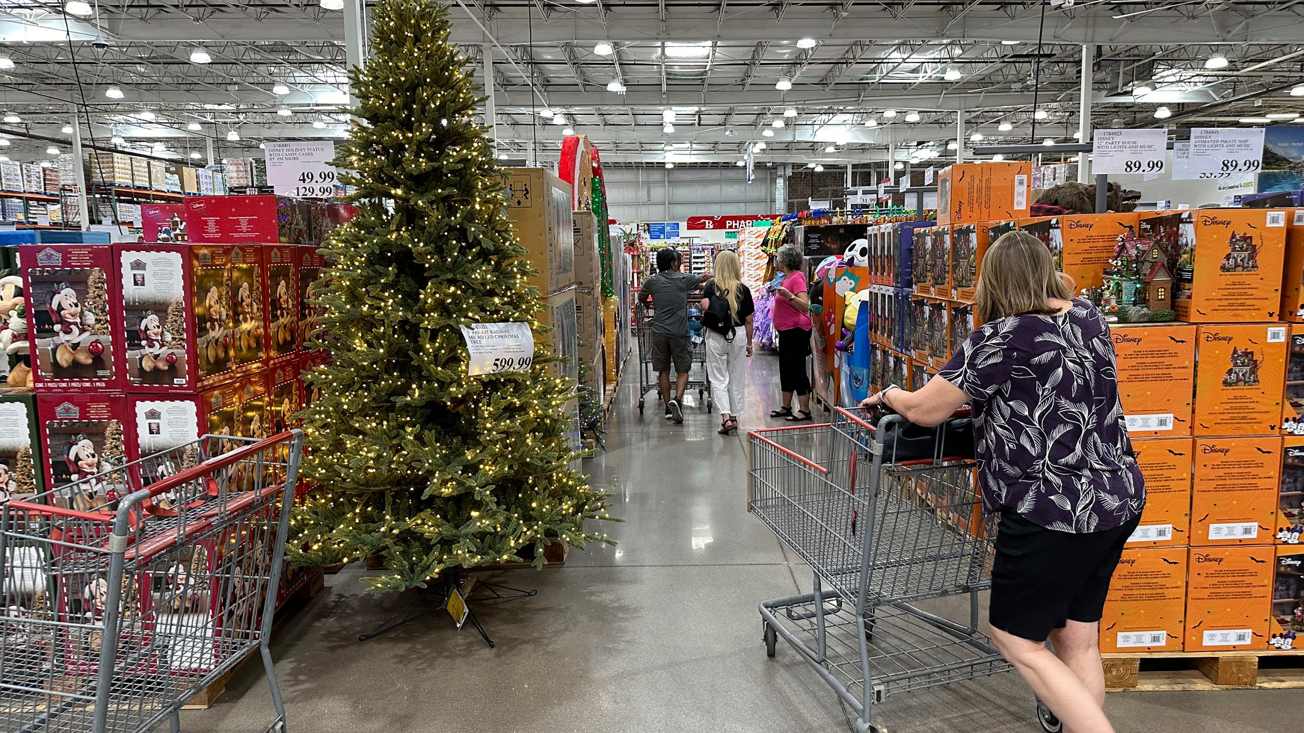 FILE - A shopper passes by a Christmas tree costing $600 on display in a Costco warehouse Sept. 12, 2024, in Thornton, Colo. (AP Photo/David Zalubowski, File)