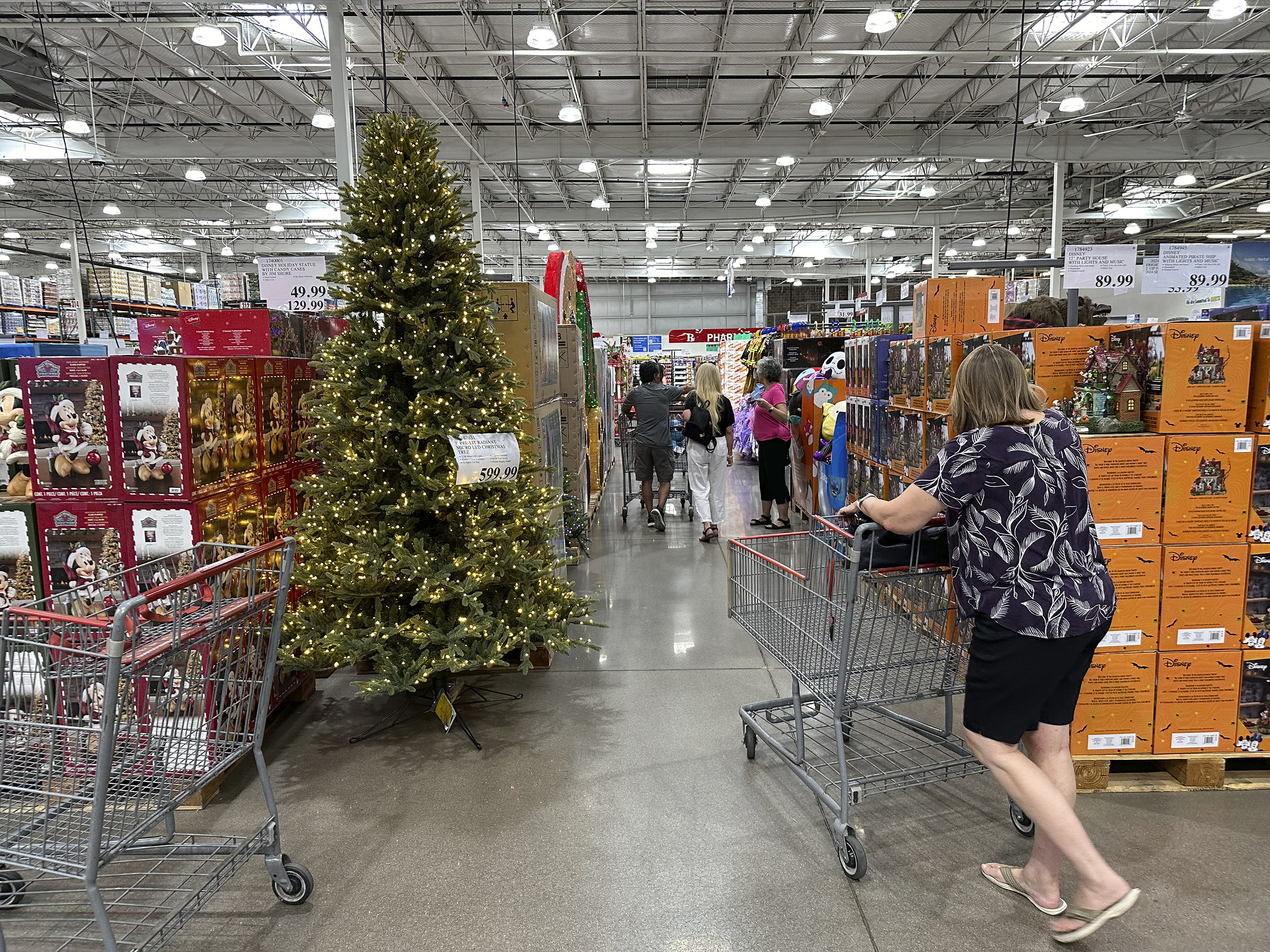 FILE - A shopper passes by a Christmas tree costing $600 on display in a Costco warehouse Sept. 12, 2024, in Thornton, Colo. (AP Photo/David Zalubowski, File)