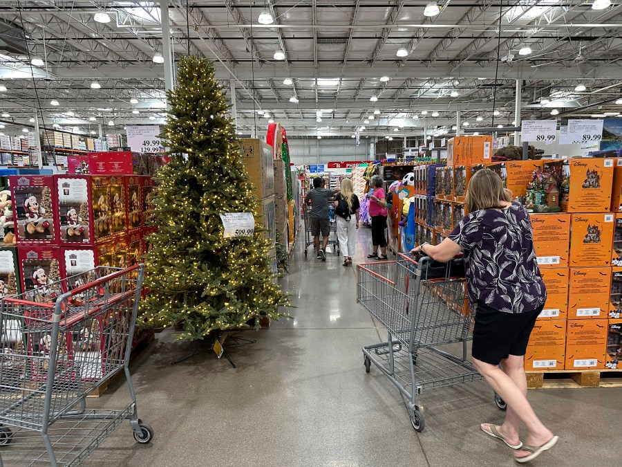 FILE - A shopper passes by a Christmas tree costing $600 on display in a Costco warehouse Sept. 12, 2024, in Thornton, Colo. (AP Photo/David Zalubowski, File)