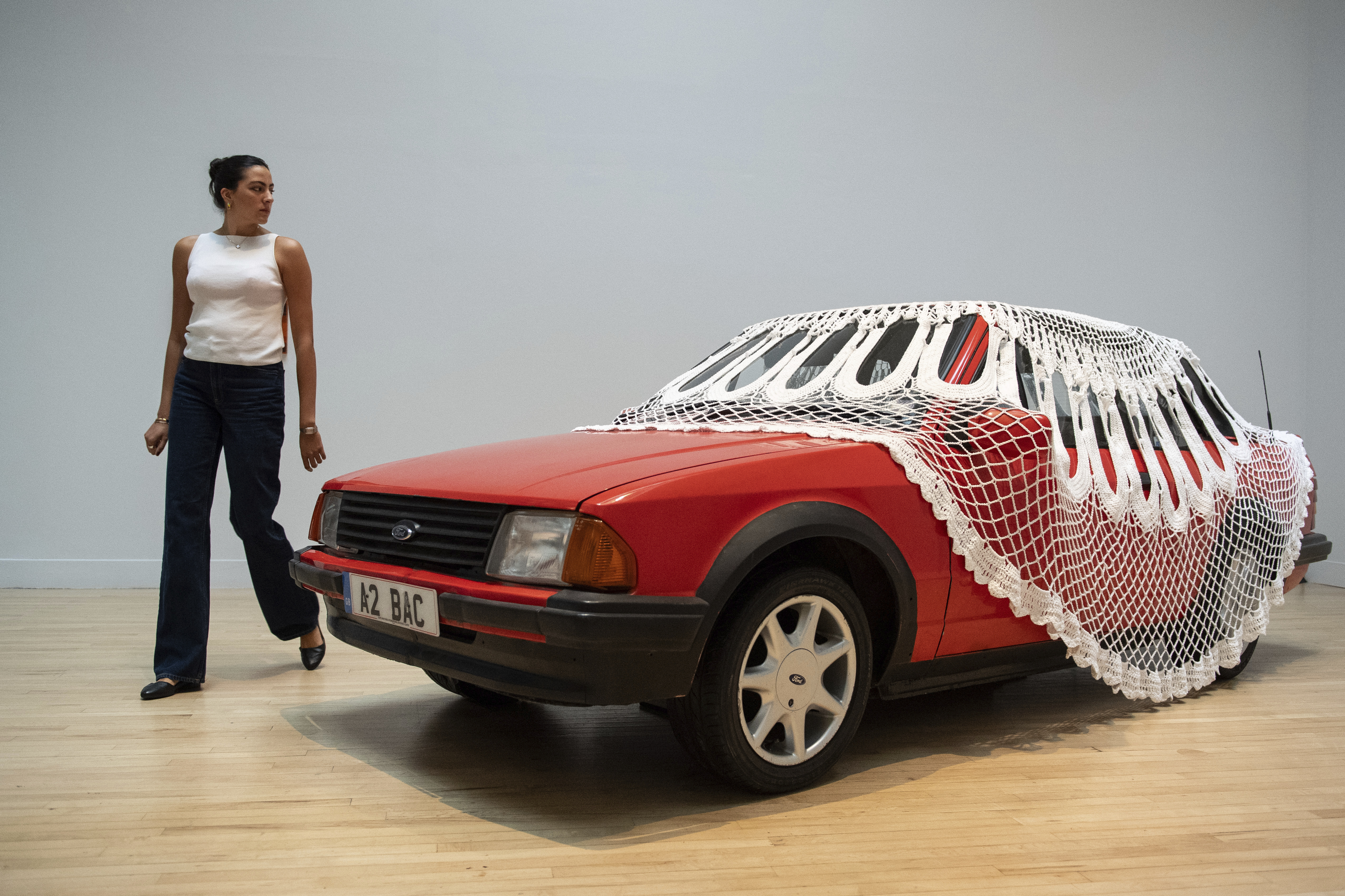 A woman passes by an artwork by Jasleen Kaur during the Turner Prize 2024 press preview at Tate Britain in London, part of the 40th anniversary exhibition featuring four shortlisted artists, Tuesday, Sept. 24, 2024. (AP Photo/Thomas Krych)