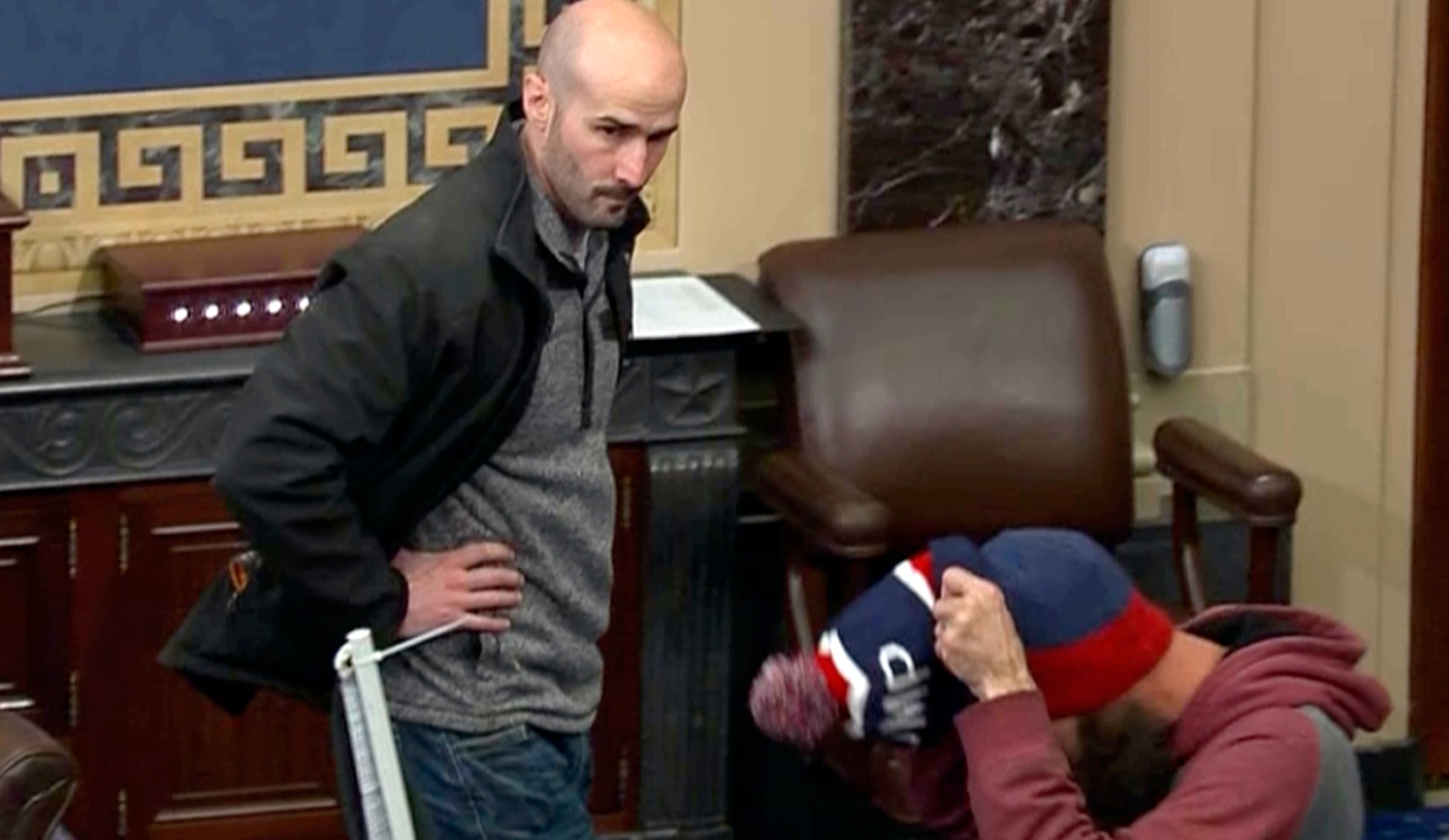 In this image from Senate Television, Leo Christopher Kelly, walks on the floor in the Senate chamber Jan. 6, 2021, at the U.S. Capitol in Washington. The federal Bureau of Prisons mistakenly released Kelly from custody before he finished serving his 30-month sentence for storming the Senate chamber during a mob's attack on the U.S. Capitol, Justice Department prosecutors said in a court filing. (Senate Television via AP)