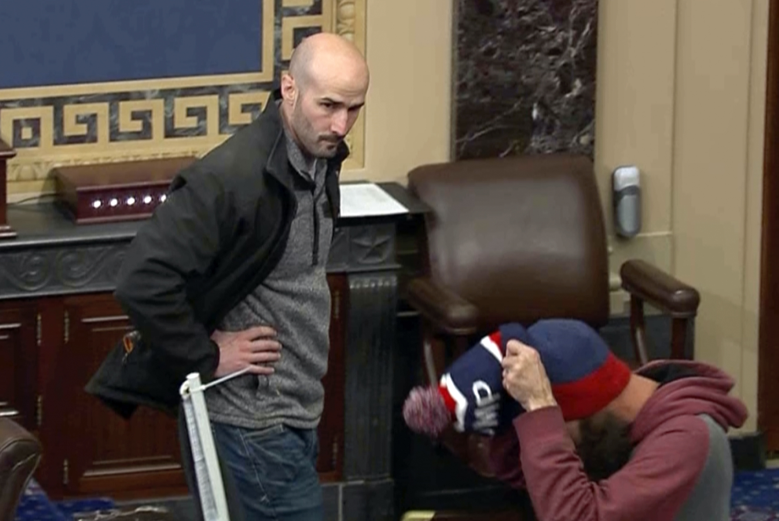 In this image from Senate Television, Leo Christopher Kelly, walks on the floor in the Senate chamber Jan. 6, 2021, at the U.S. Capitol in Washington. The federal Bureau of Prisons mistakenly released Kelly from custody before he finished serving his 30-month sentence for storming the Senate chamber during a mob's attack on the U.S. Capitol, Justice Department prosecutors said in a court filing. (Senate Television via AP)