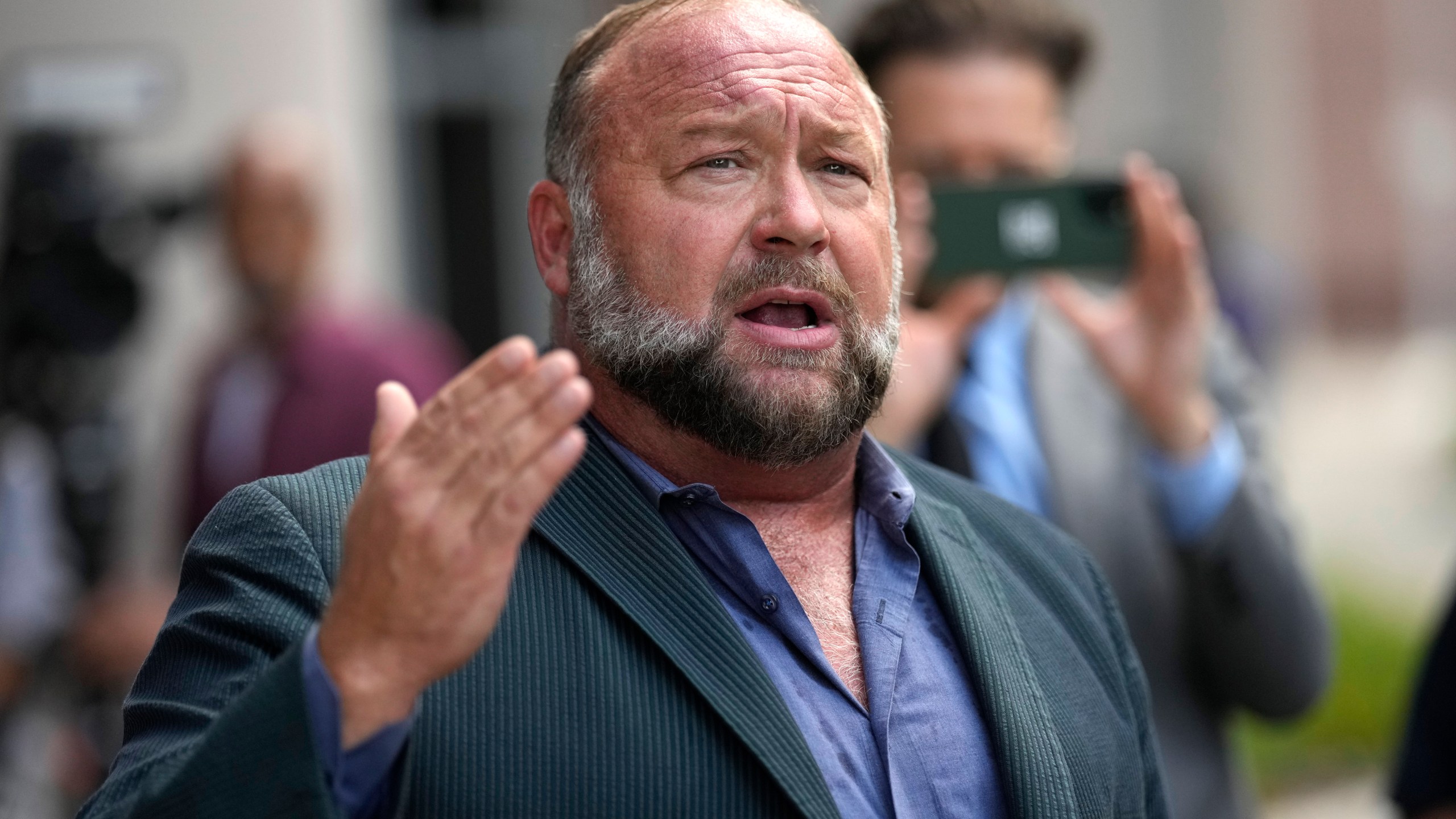 FILE - Alex Jones speaks to the media after arriving at the federal courthouse for a hearing in front of a bankruptcy judge, June 14, 2024, in Houston. (AP Photo/David J. Phillip, File)