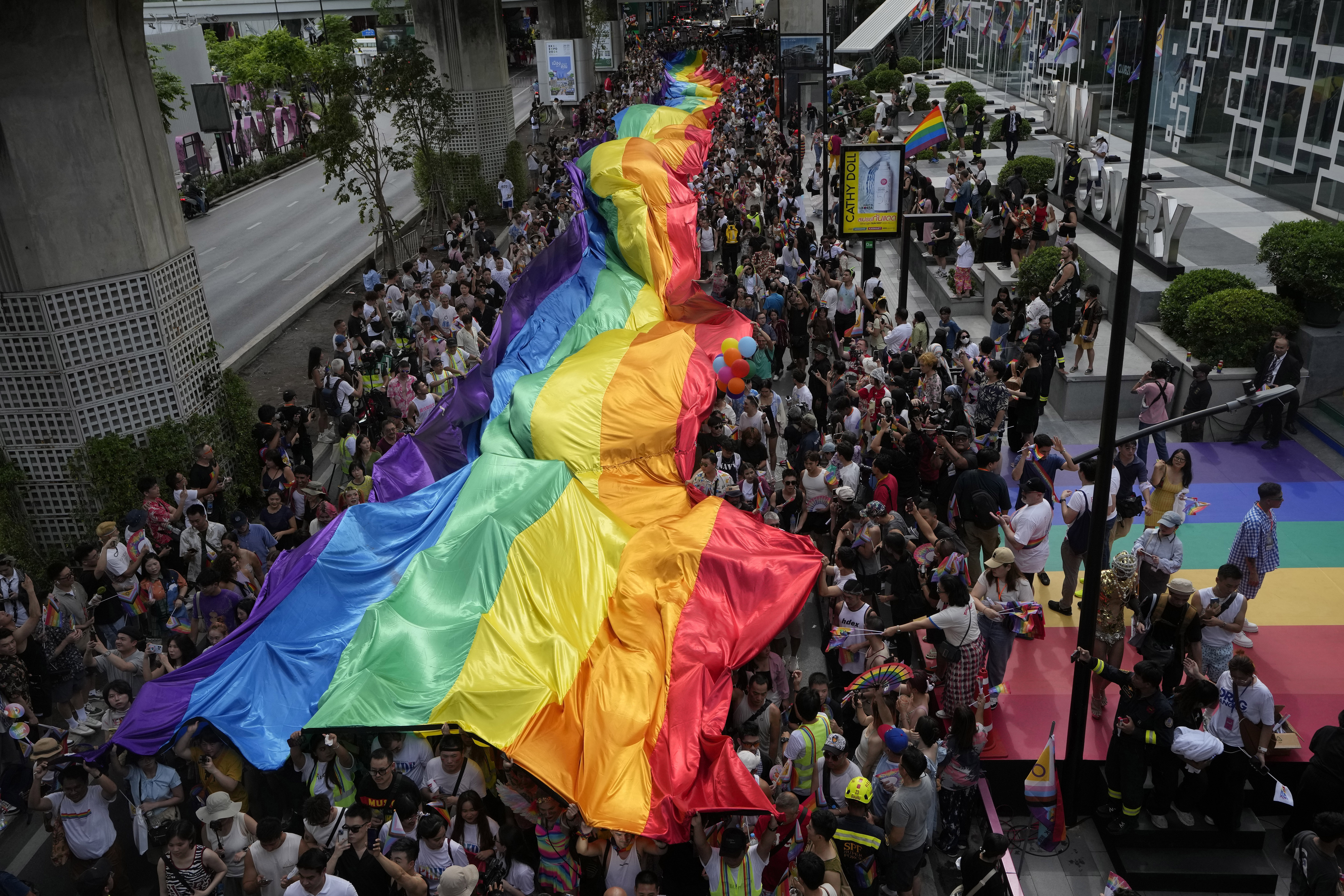 FILE - Participants hold a rainbow flag during the Pride Parade in Bangkok, Thailand, Saturday, June 1, 2024. (AP Photo/Sakchai Lalit, File)