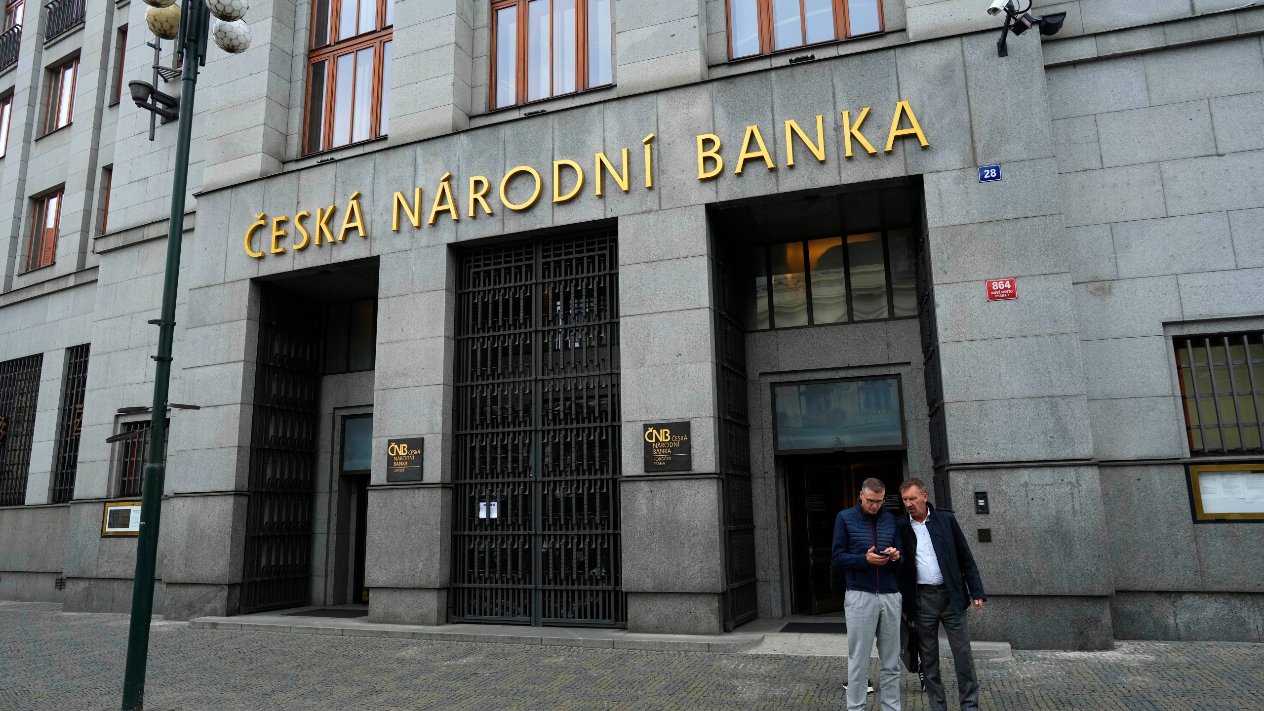 FILE - People stand outside the Czech central bank in Prague, Czech Republic, Thursday, Nov. 2, 2023. (AP Photo/Petr David Josek, File)