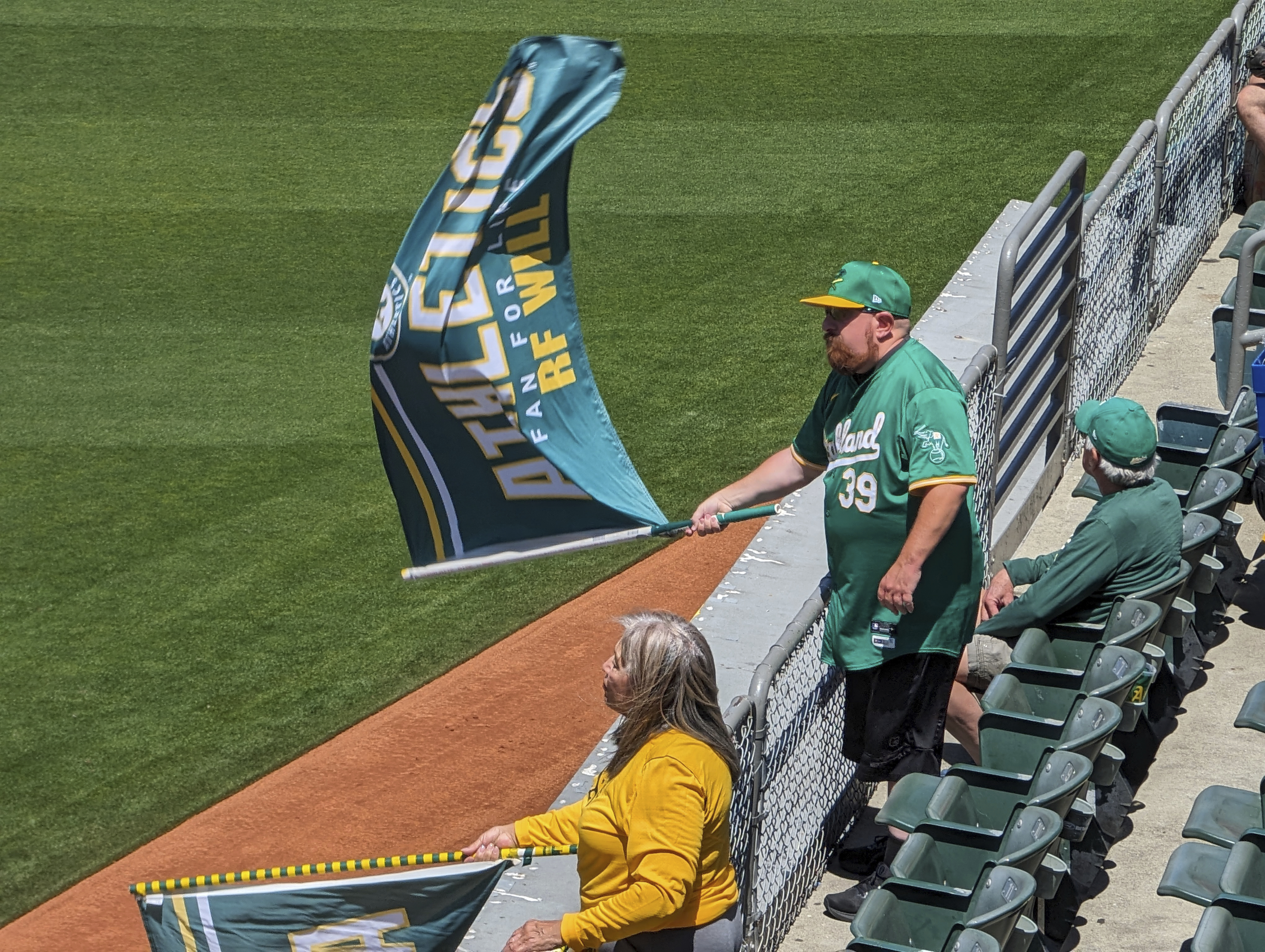 "Right-Field" Will MacNeil waves an A's flag as the home team prepares to take to the field during a game at the Oakland Coliseum on May 1, 2024, in Oakland, Calif.. (AP Photo/Michael Liedtke)