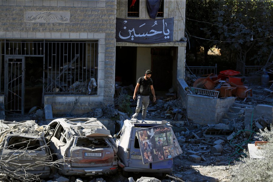 A man stands on top of a damaged car at the site of an Israeli airstrike in Saksakieh, south Lebanon, Thursday, Sept. 26, 2024. (AP Photo/Mohammed Zaatari)