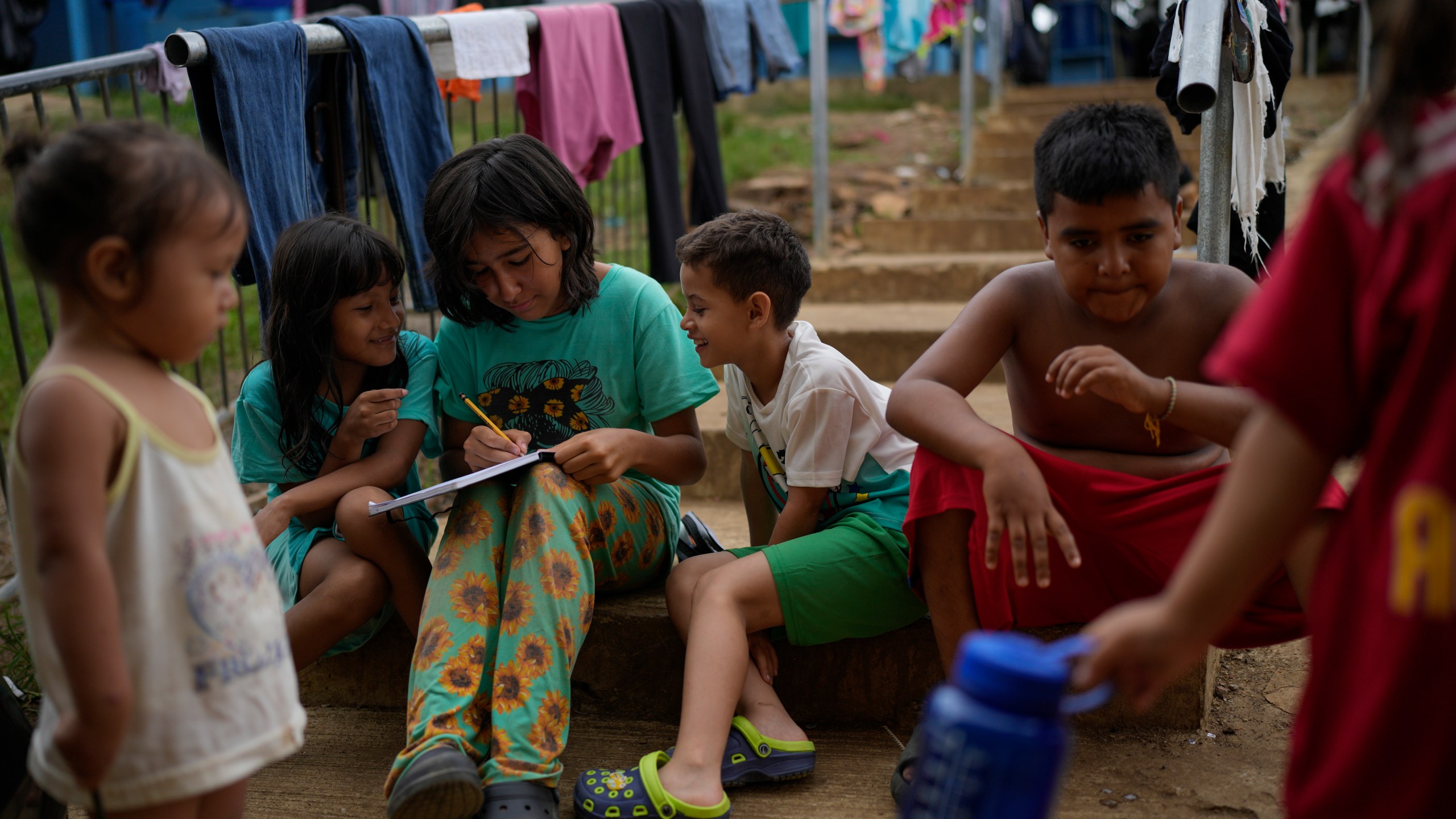 Children play at a camp for migrants in Lajas Blancas, Panama, after walking across the Darien Gap in hopes of reaching the U.S., Thursday, Sept. 26, 2024. (AP Photo/Matias Delacroix)