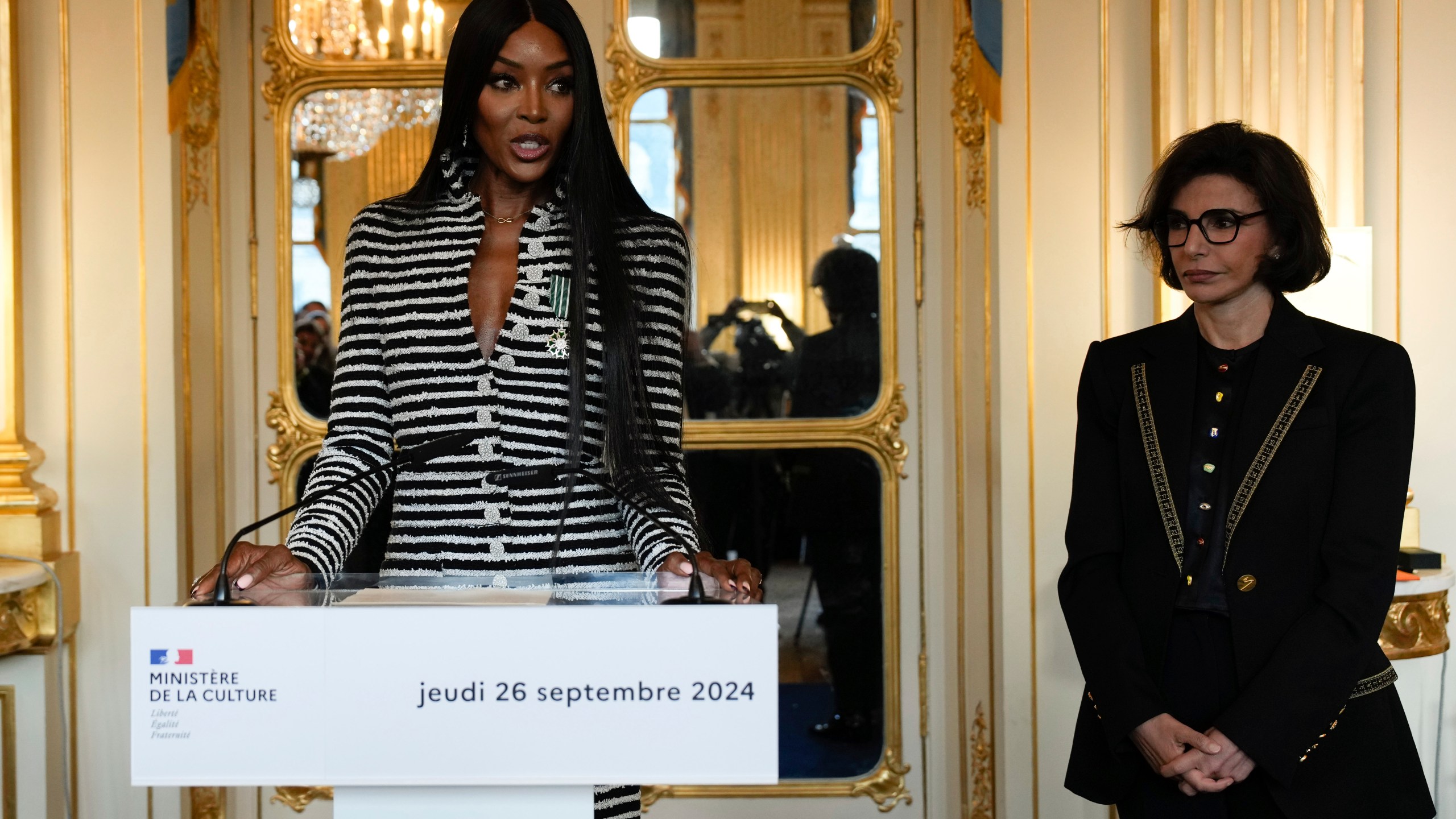 Naomi Campbell delivers a speech after being awarded with the medal of "Chevalier de l'Ordres des Arts et des Lettres", by French Culture Minister Rachida Dati, right, at the Culture ministry, in Paris, Thursday, Sept. 26, 2024. (AP Photo/Louise Delmotte)