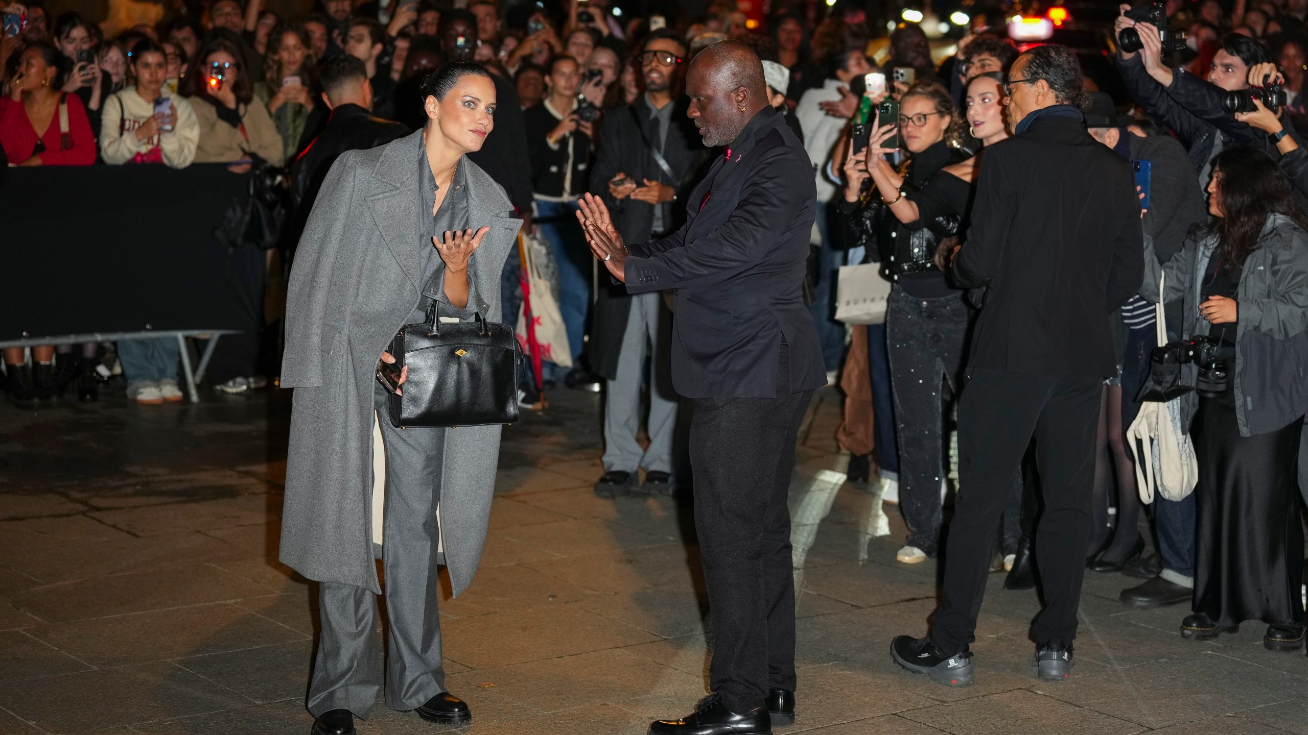 Adriana Lima, left, speaks with a security guard upon departure from the Schiaparelli Spring/Summer 2025 collection presented Thursday, Sept. 26, 2024, in Paris. (Photo by Scott A Garfitt/Invision/AP)