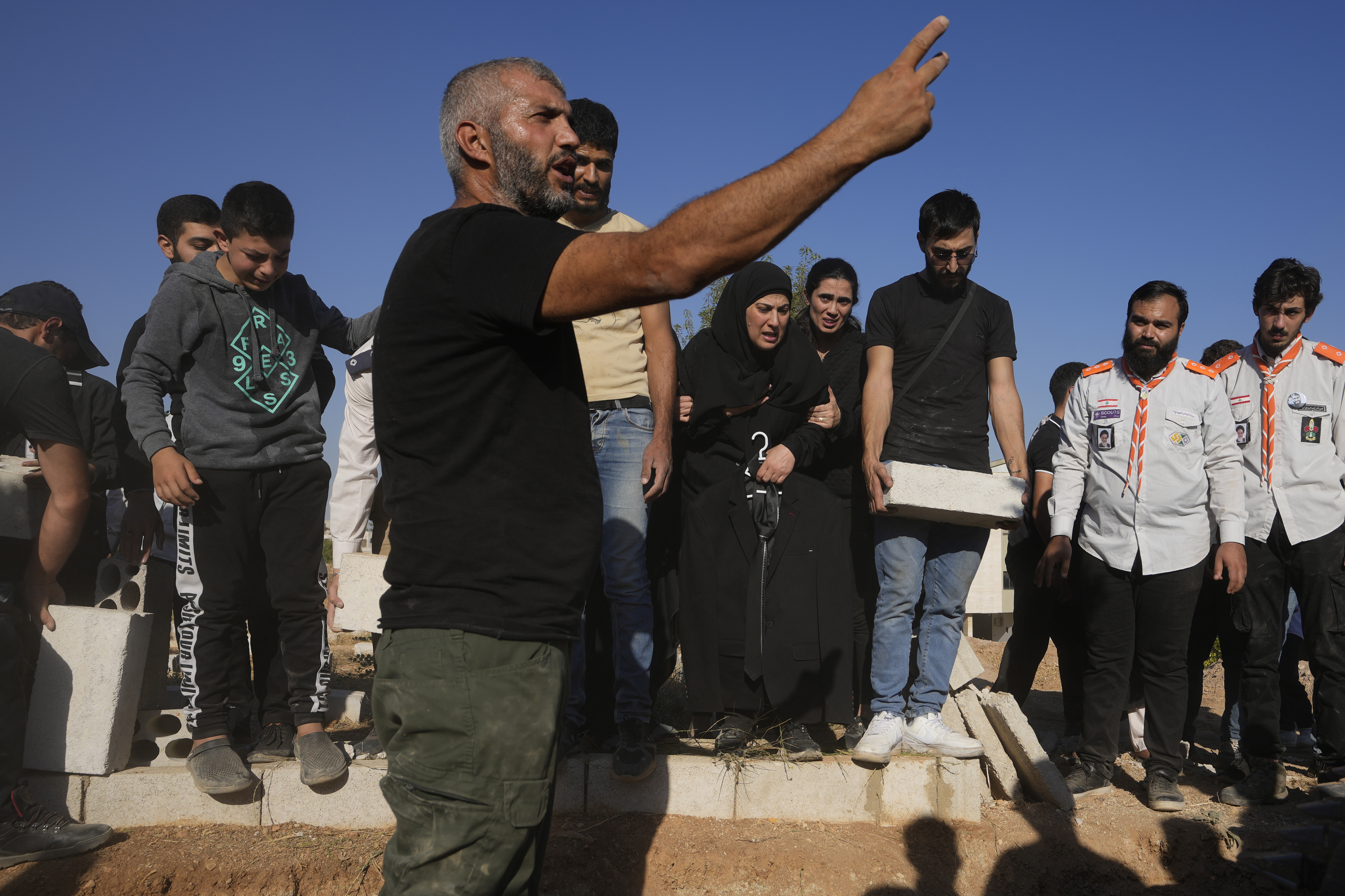 Mourners bury the bodies of their relatives, killed in Israeli airstrikes in the village of Karak, Bekaa Valley, eastern Lebanon, Friday, Sept. 27, 2024. (AP Photo/Hassan Ammar)