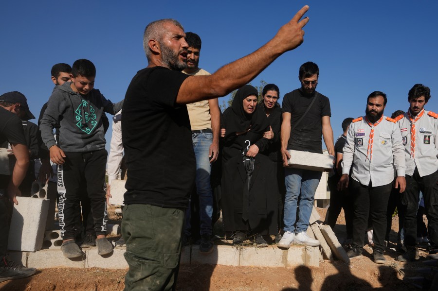 Mourners bury the bodies of their relatives, killed in Israeli airstrikes in the village of Karak, Bekaa Valley, eastern Lebanon, Friday, Sept. 27, 2024. (AP Photo/Hassan Ammar)